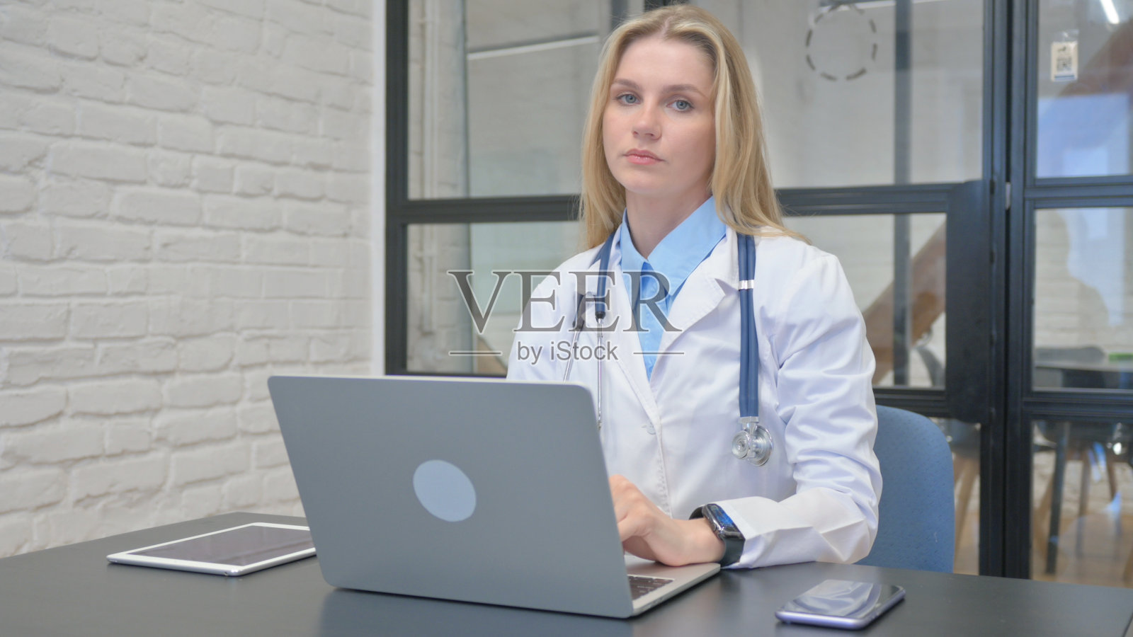 年轻女医生在医院里看着镜头,拇指向下照片摄影图片