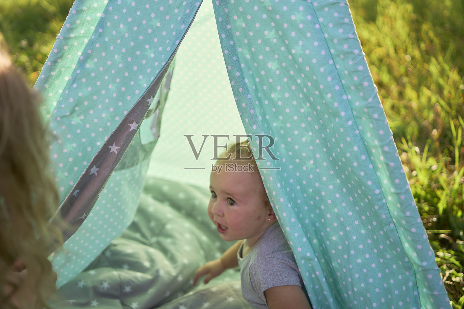 一家人带着蹒跚学步的孩子在花园的棚屋里玩耍照片摄影图片