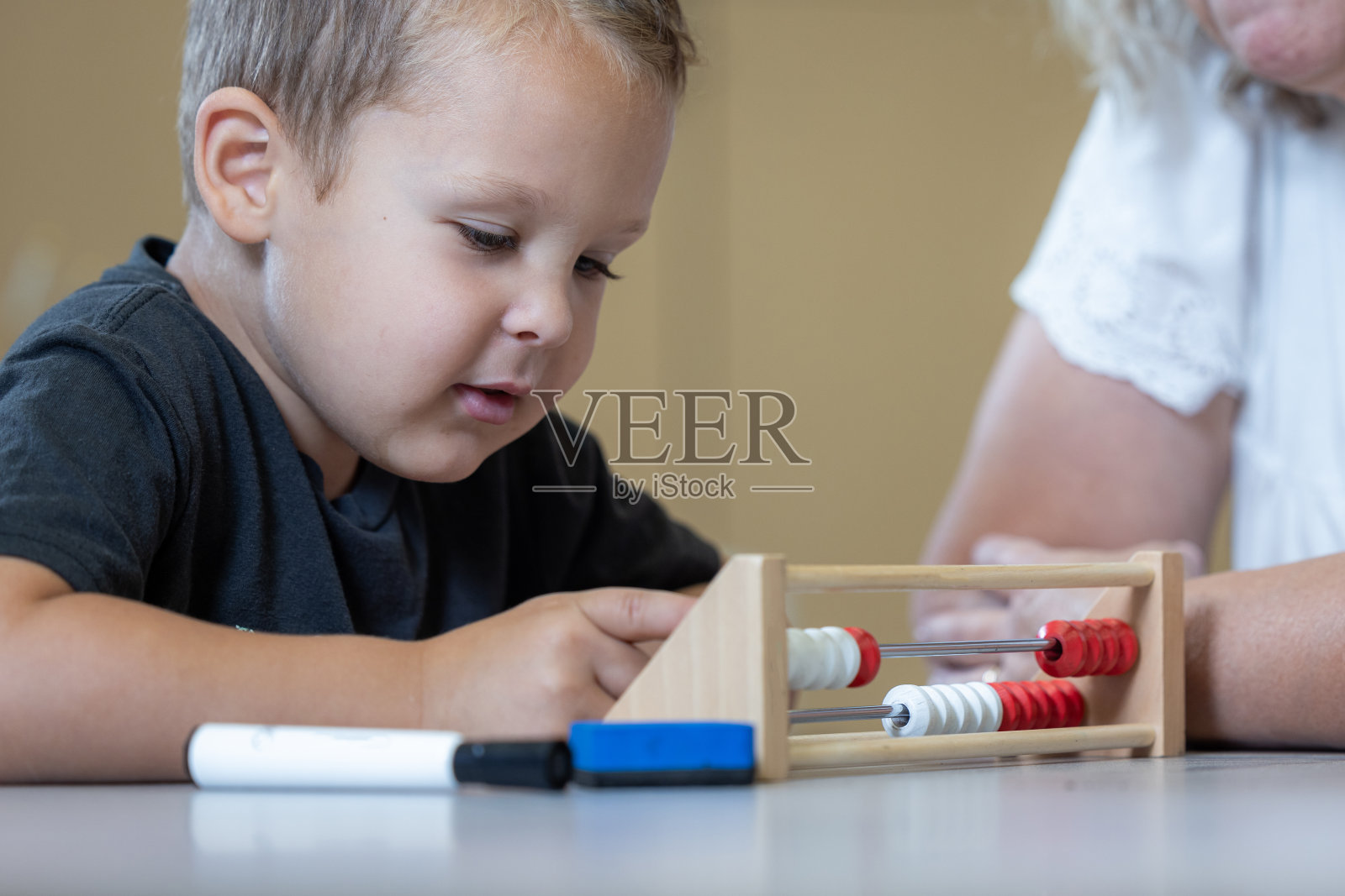 一个小男孩正在用木算盘数数照片摄影图片