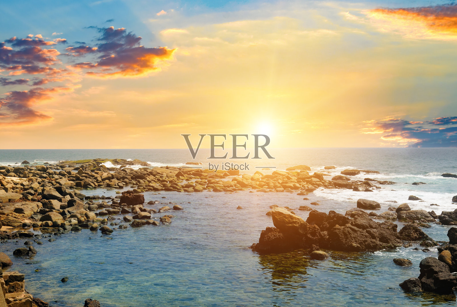 美丽的海浪,岩石海岸和明亮的日出海景。照片摄影图片