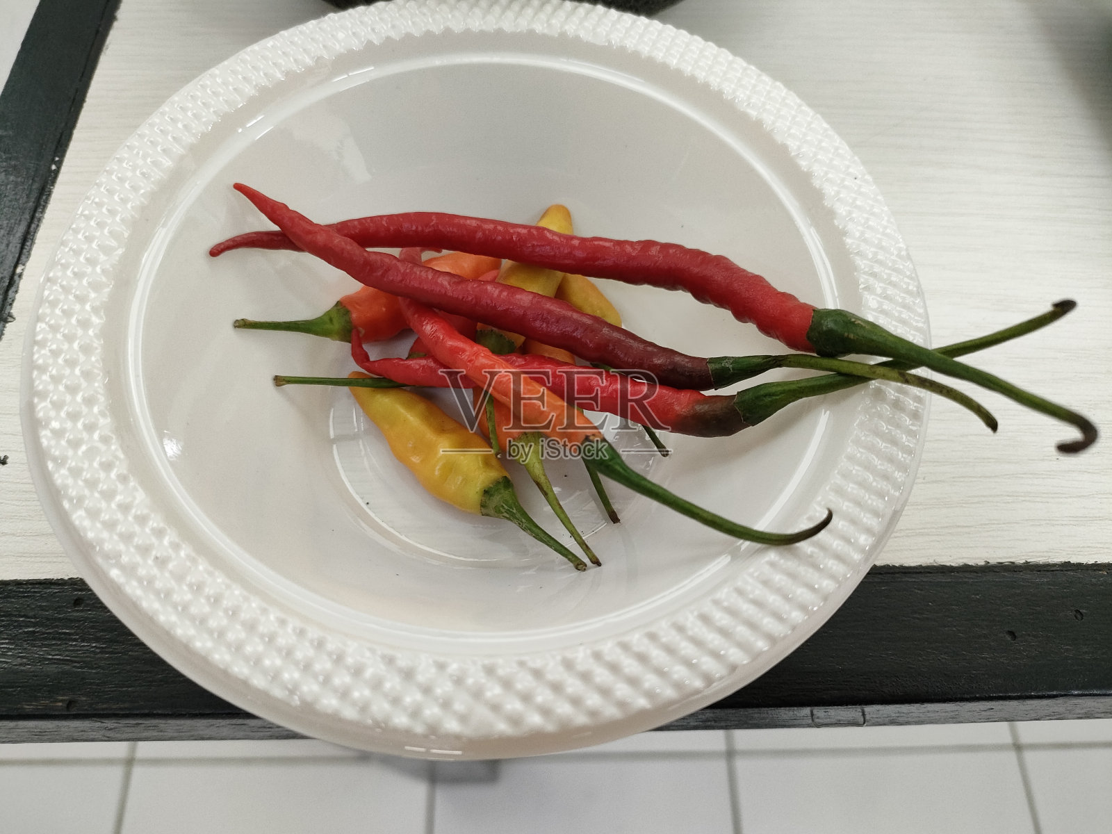 辣椒放在白色塑料碗里照片摄影图片