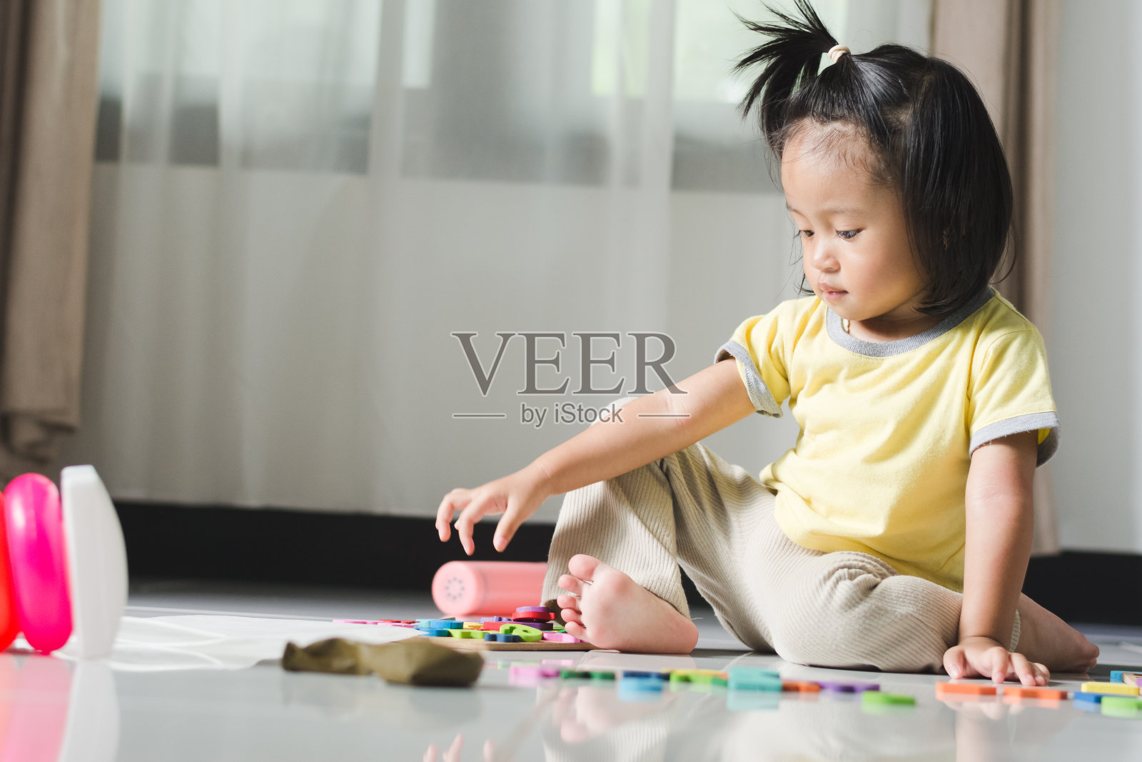 好奇的幼儿在地板上玩彩色木制拼图照片摄影图片