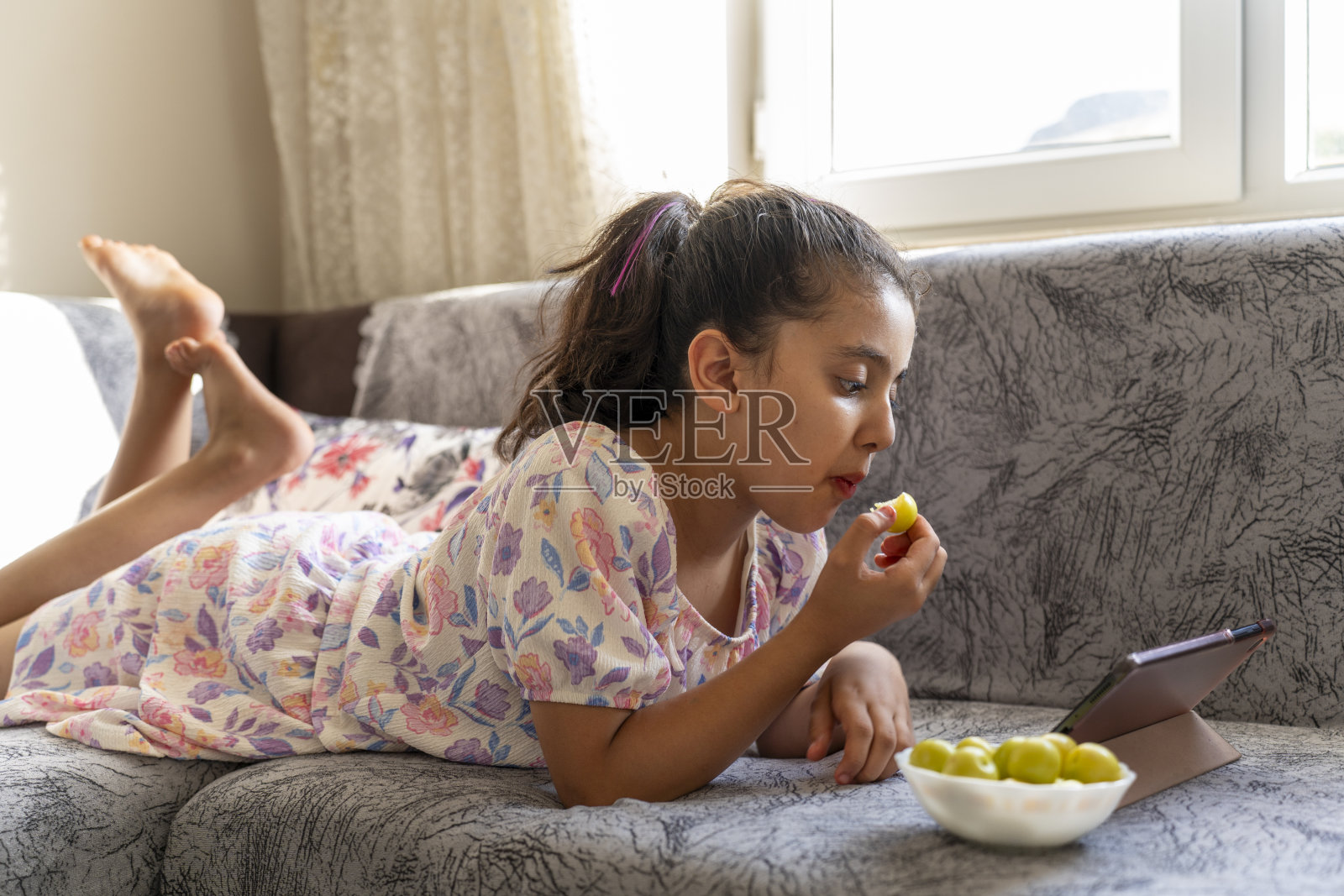 一个女孩一边吃水果一边用药片。照片摄影图片