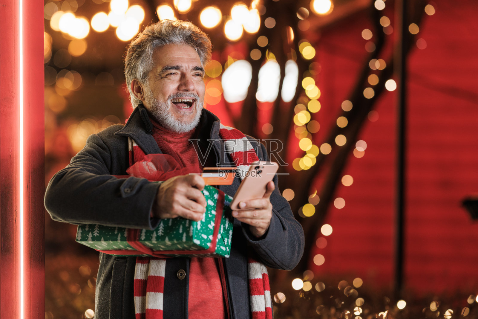 圣诞期间,一个快乐的成熟男人用信用卡在网上购物照片摄影图片