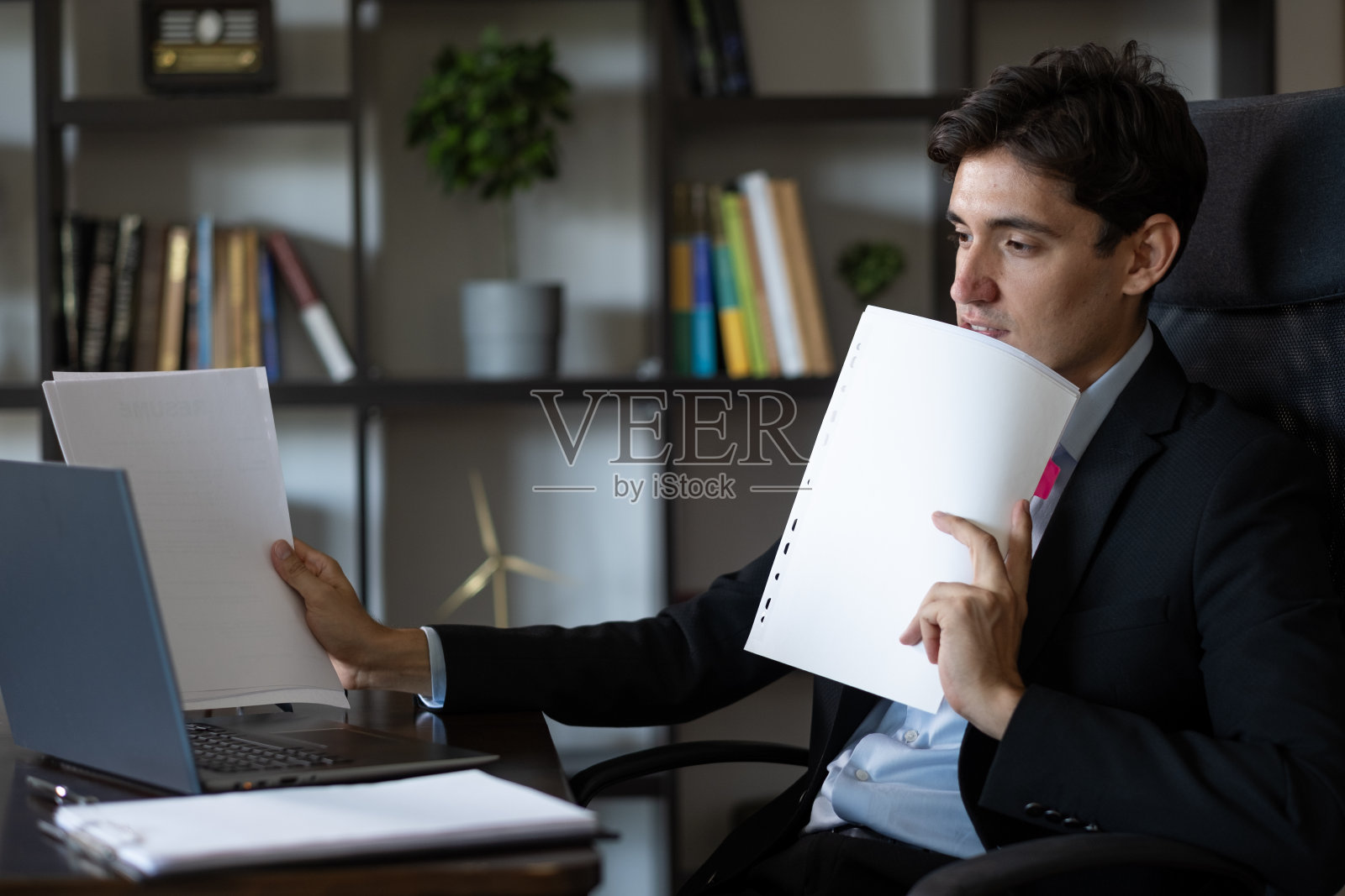 穿着西装的年轻商人在网上与他的文件对话照片摄影图片