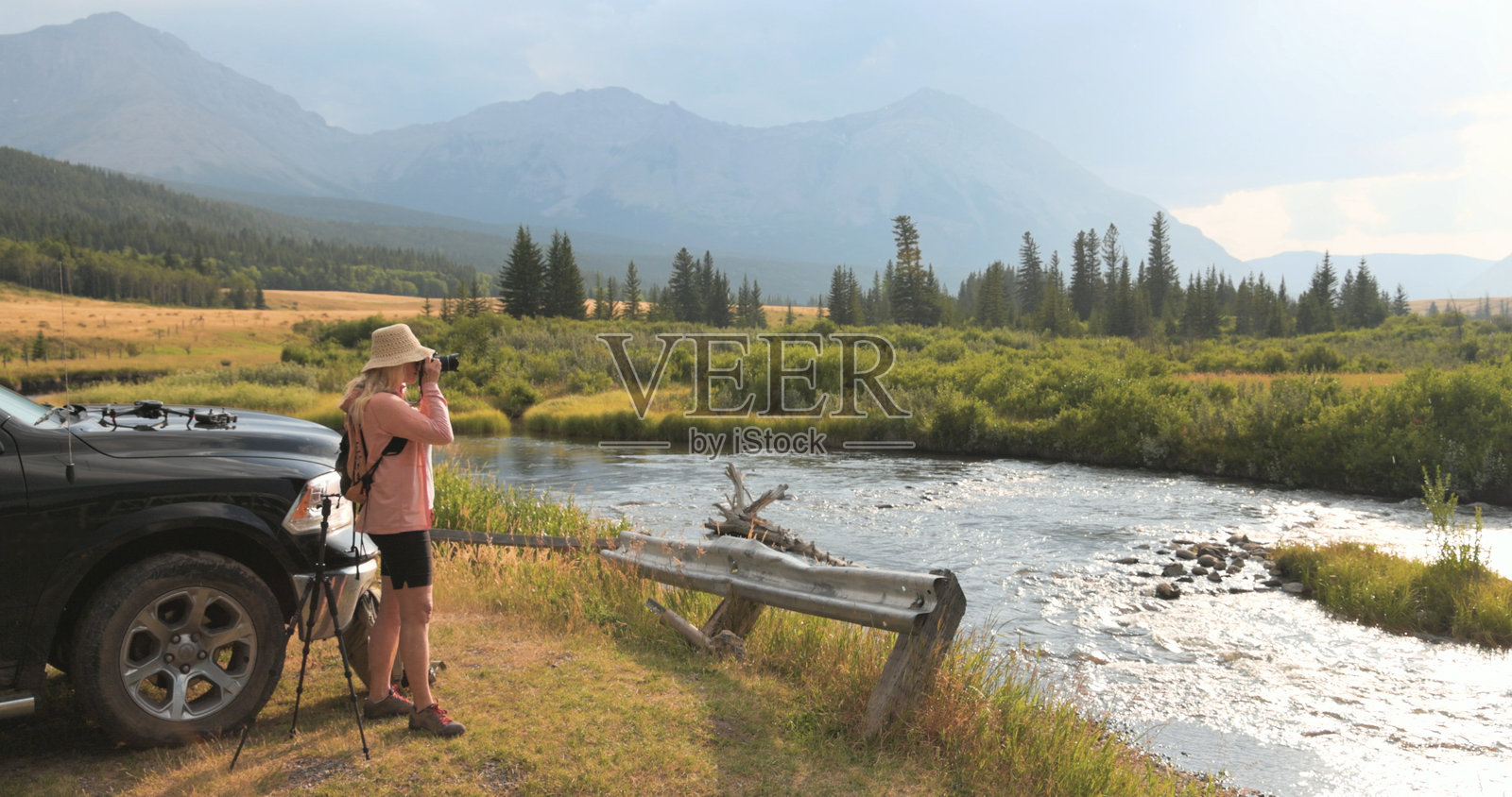 成熟的女子在车辆旁拍照照片摄影图片