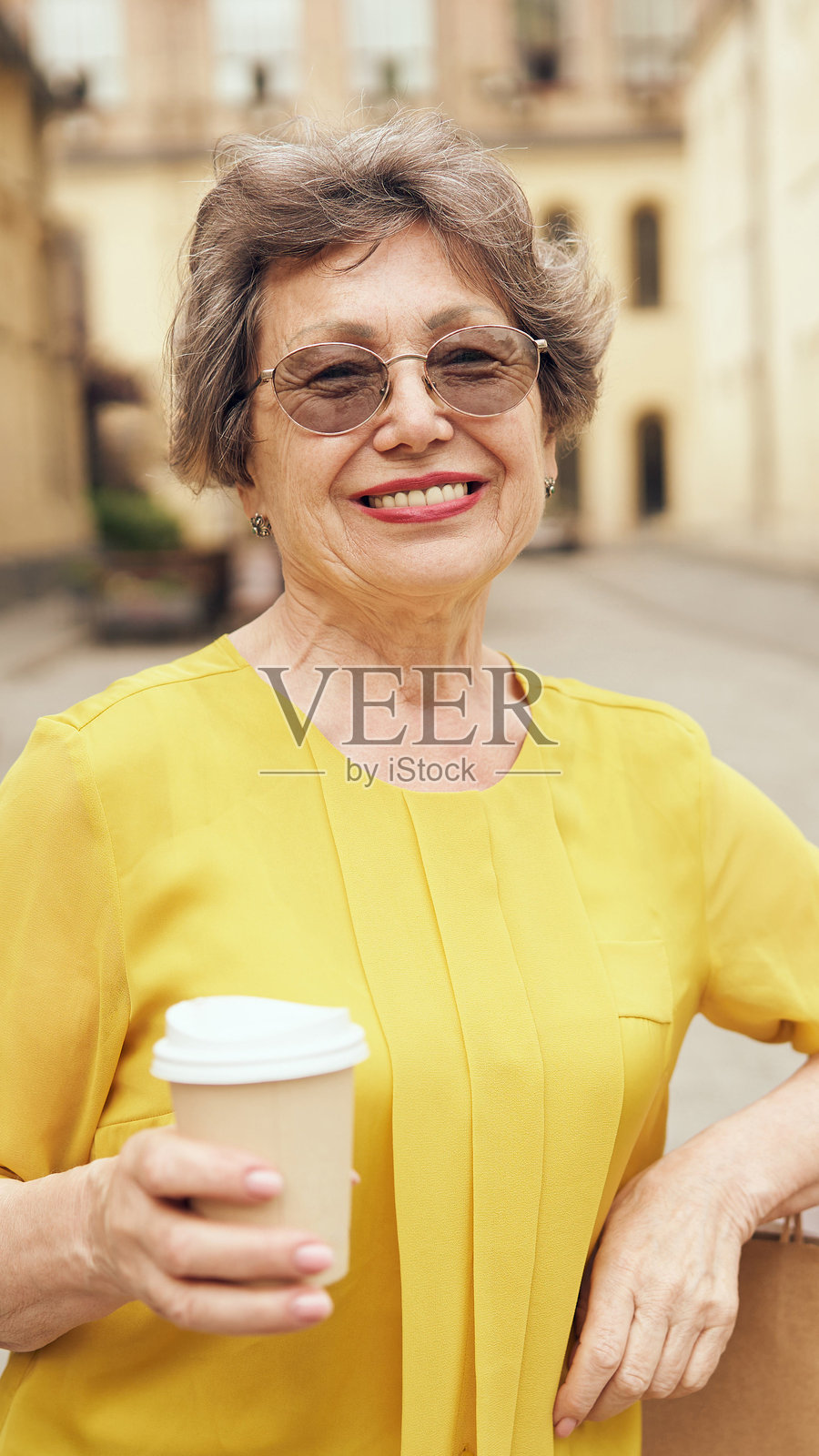 一位快乐的老妇人在户外温暖愉快的环境中享受着她的咖啡照片摄影图片