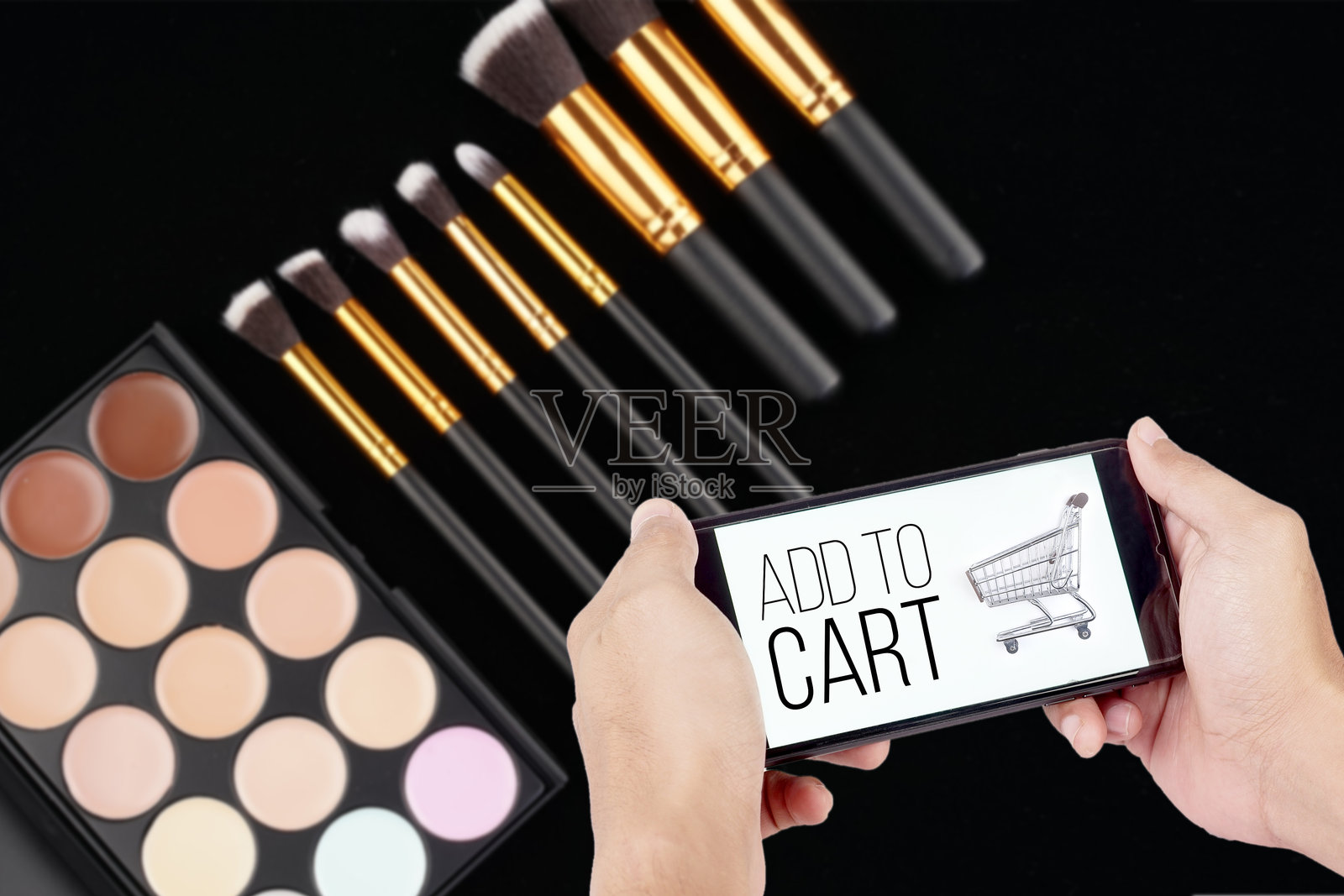 黑色背景下使用手机的人在网上购物时裁剪的手照片摄影图片