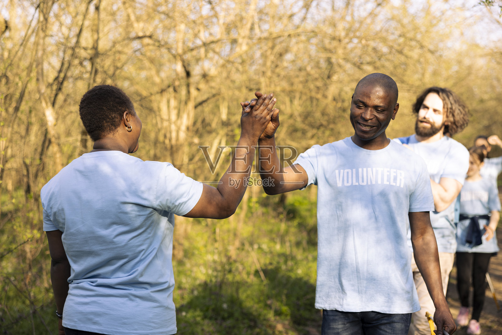 一群环保人士在工作完成后击掌庆祝照片摄影图片