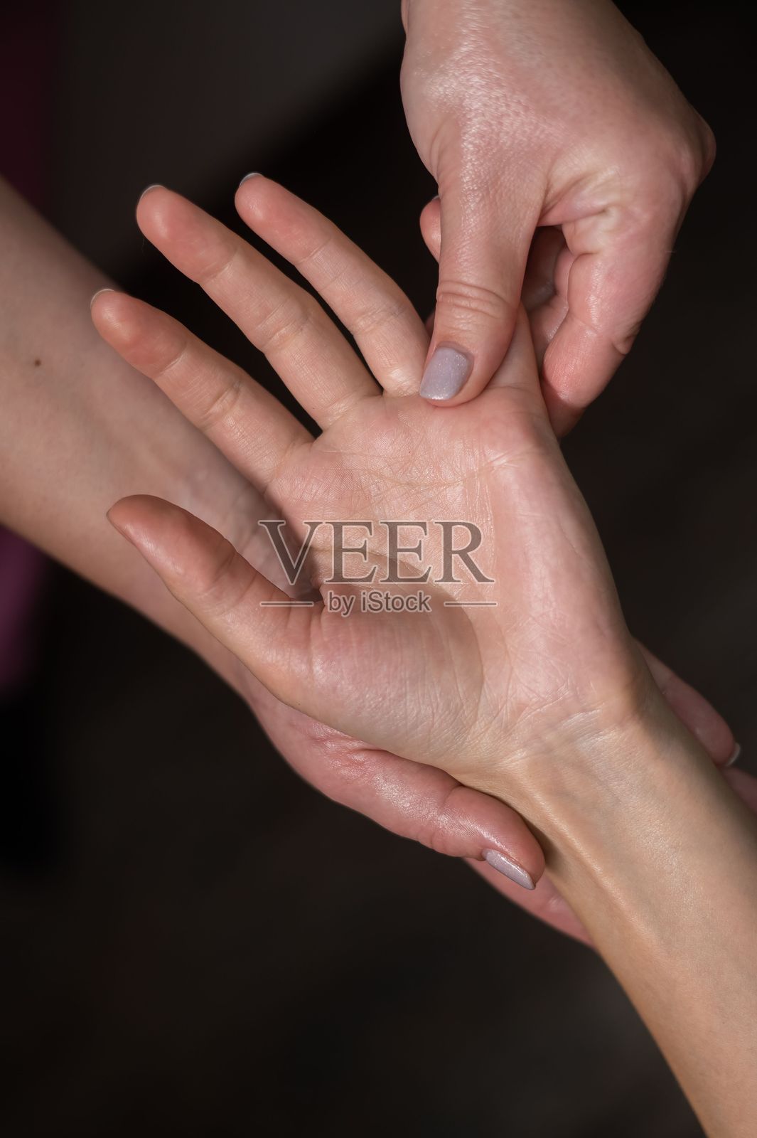 女按摩师按摩病人的手掌。水疗治疗时的手部特写。垂直的照片。照片摄影图片