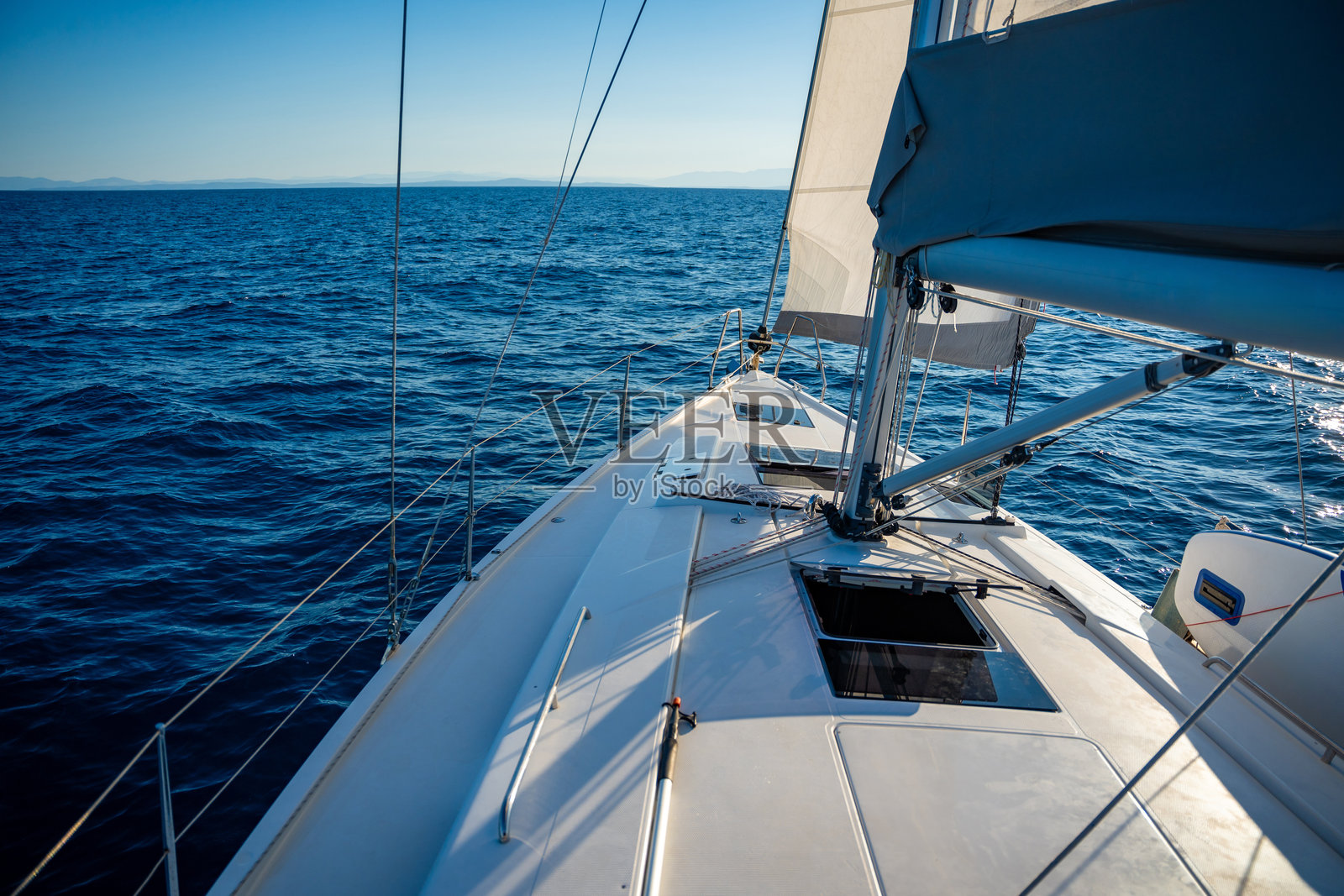 在公海上航行的游艇。甲板、桅杆和帆的特写。游艇的概念照片摄影图片