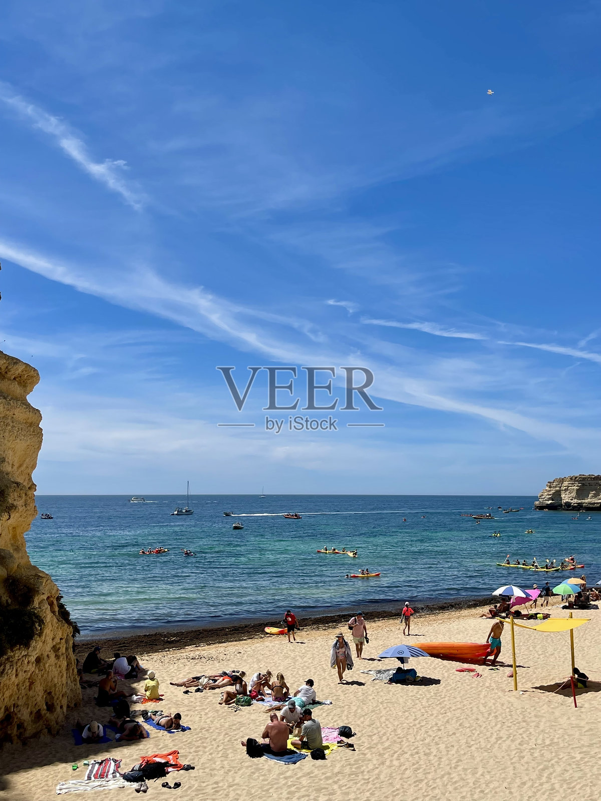 拉各斯,阿尔加维海岸,葡萄牙- 2023年8月12日:夏天的一天,阿尔加维海岸繁忙的海滩。人们晒日光浴,等着在海里游泳。照片摄影图片