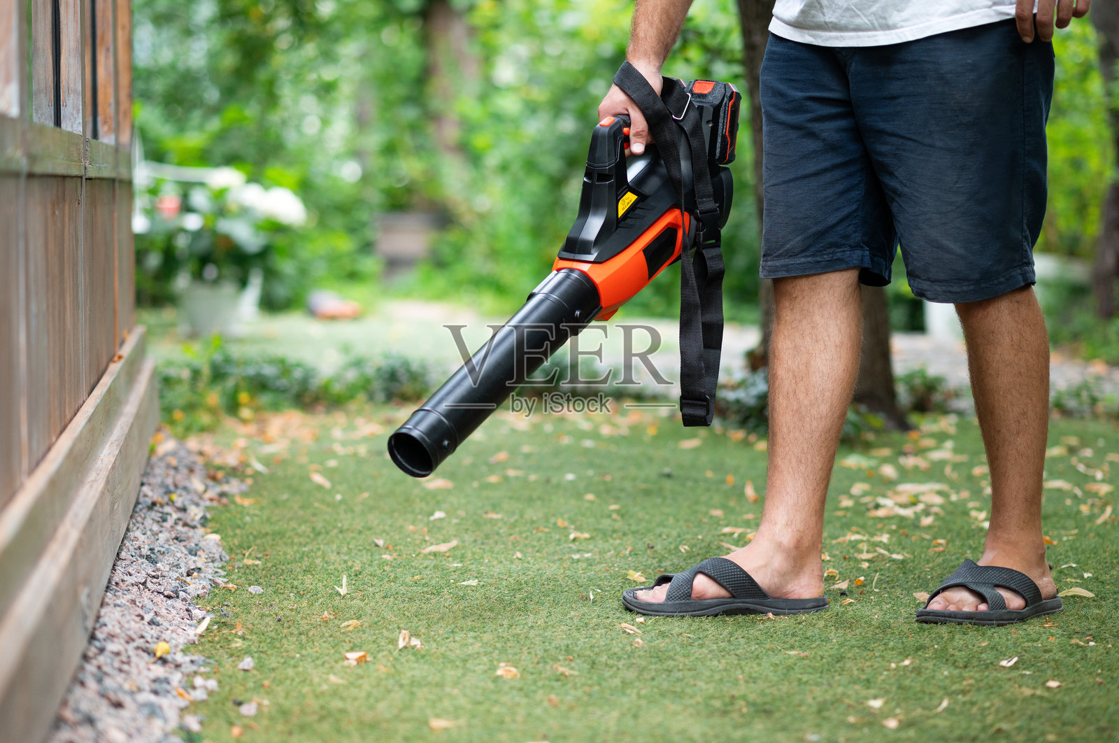 无绳吹叶机。手持,无绳,电动吹叶机在一个花园,选择性聚焦。秋天,秋天的园艺工作在后院、草坪、草地上进行。花园的工作。照片摄影图片