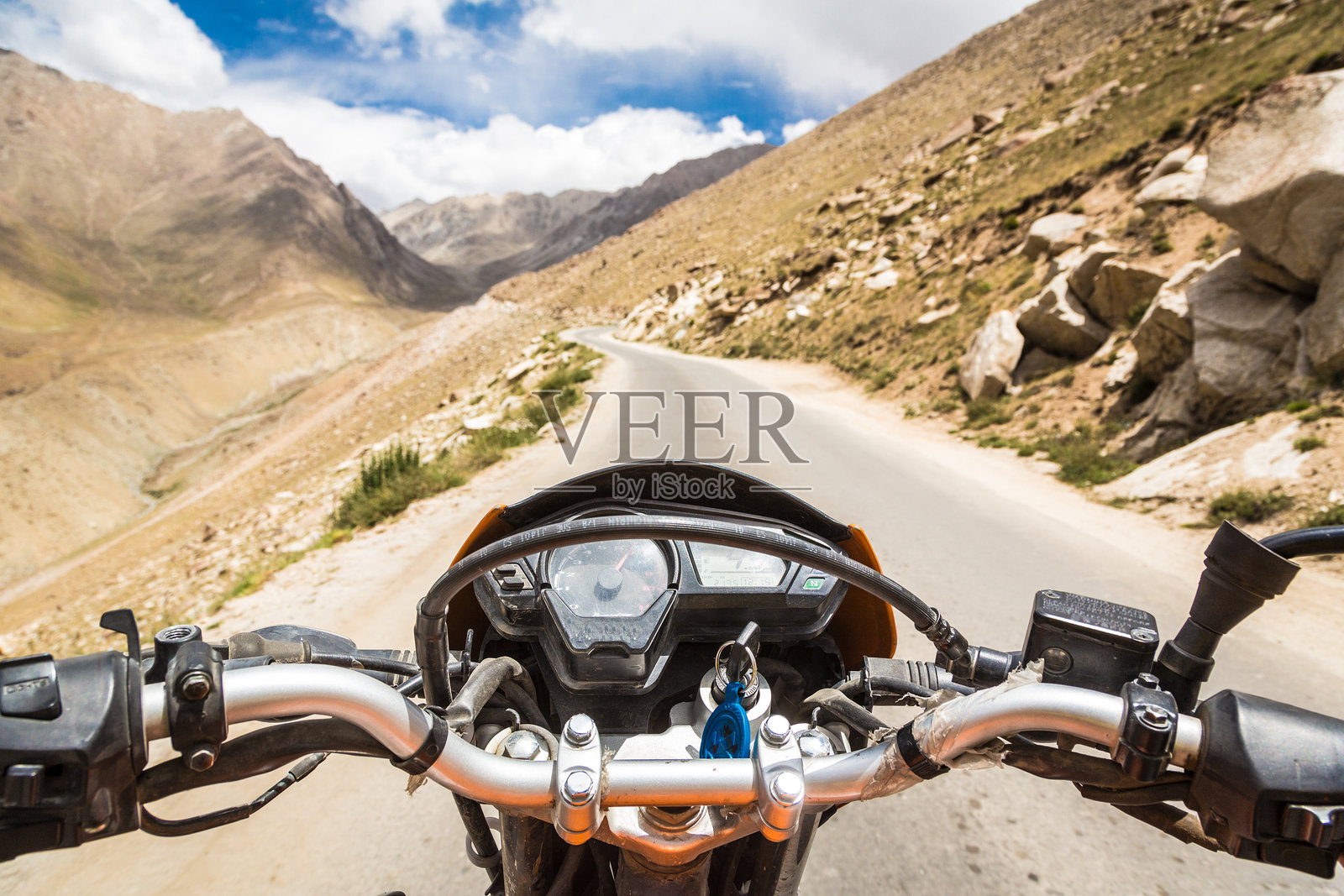 男子在沙漠公路上骑自行车,背对天空照片摄影图片