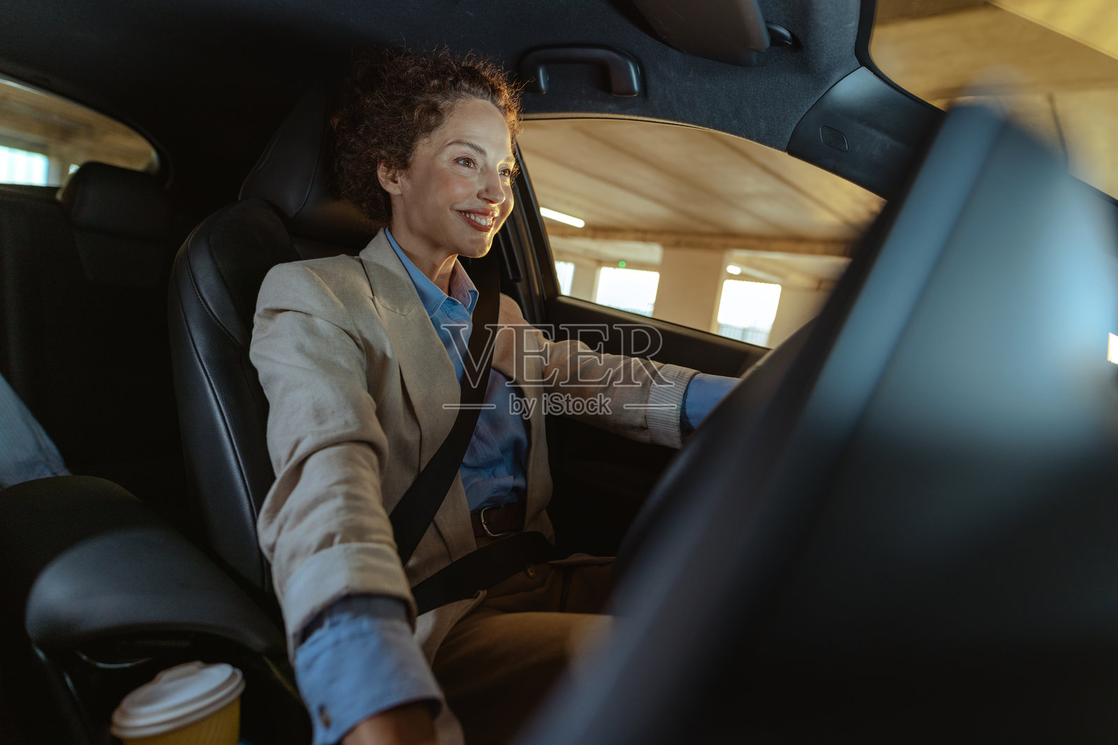 微笑的女人开着车,专注而自信照片摄影图片