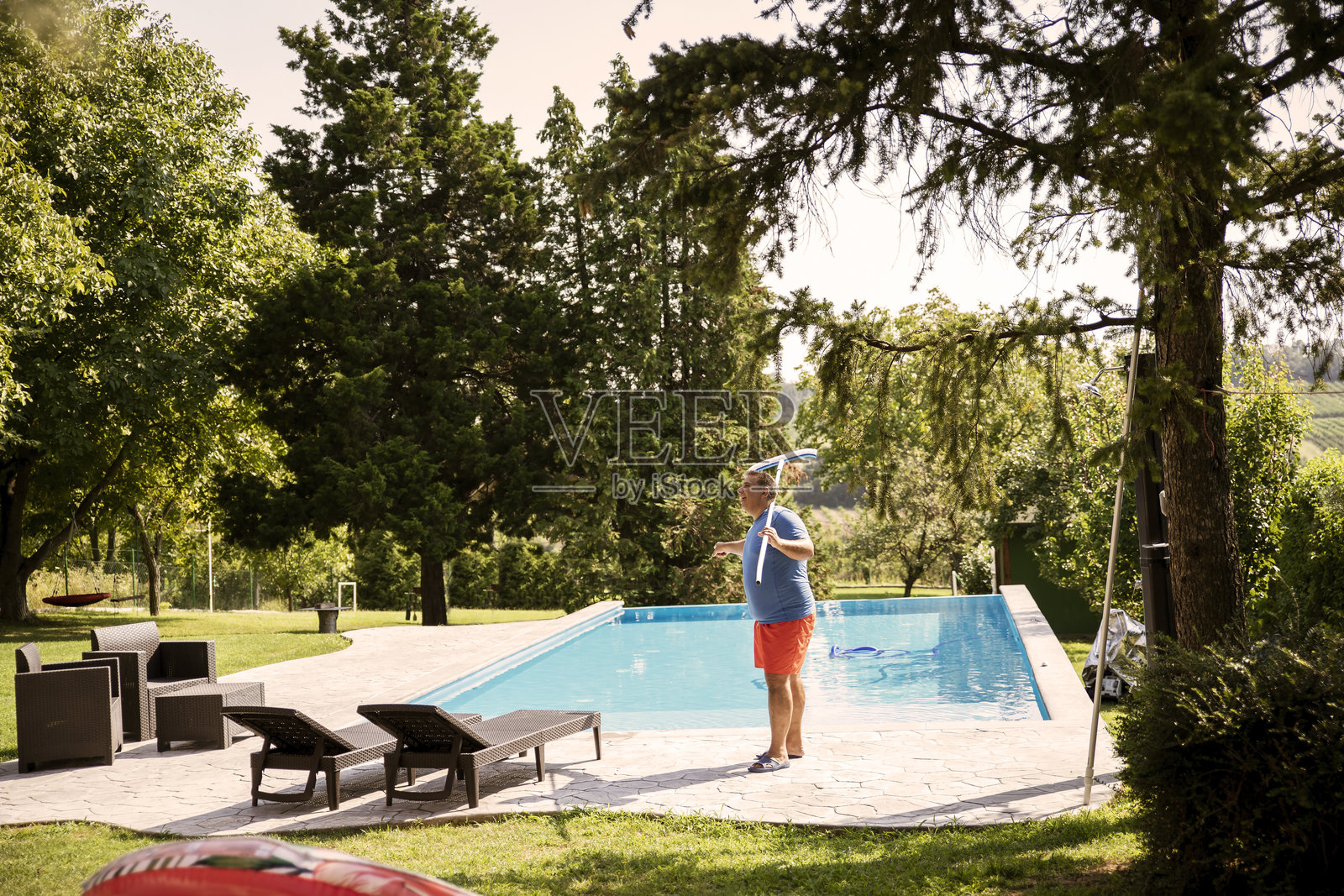 泳池清洁工在用泳池清理花园照片摄影图片