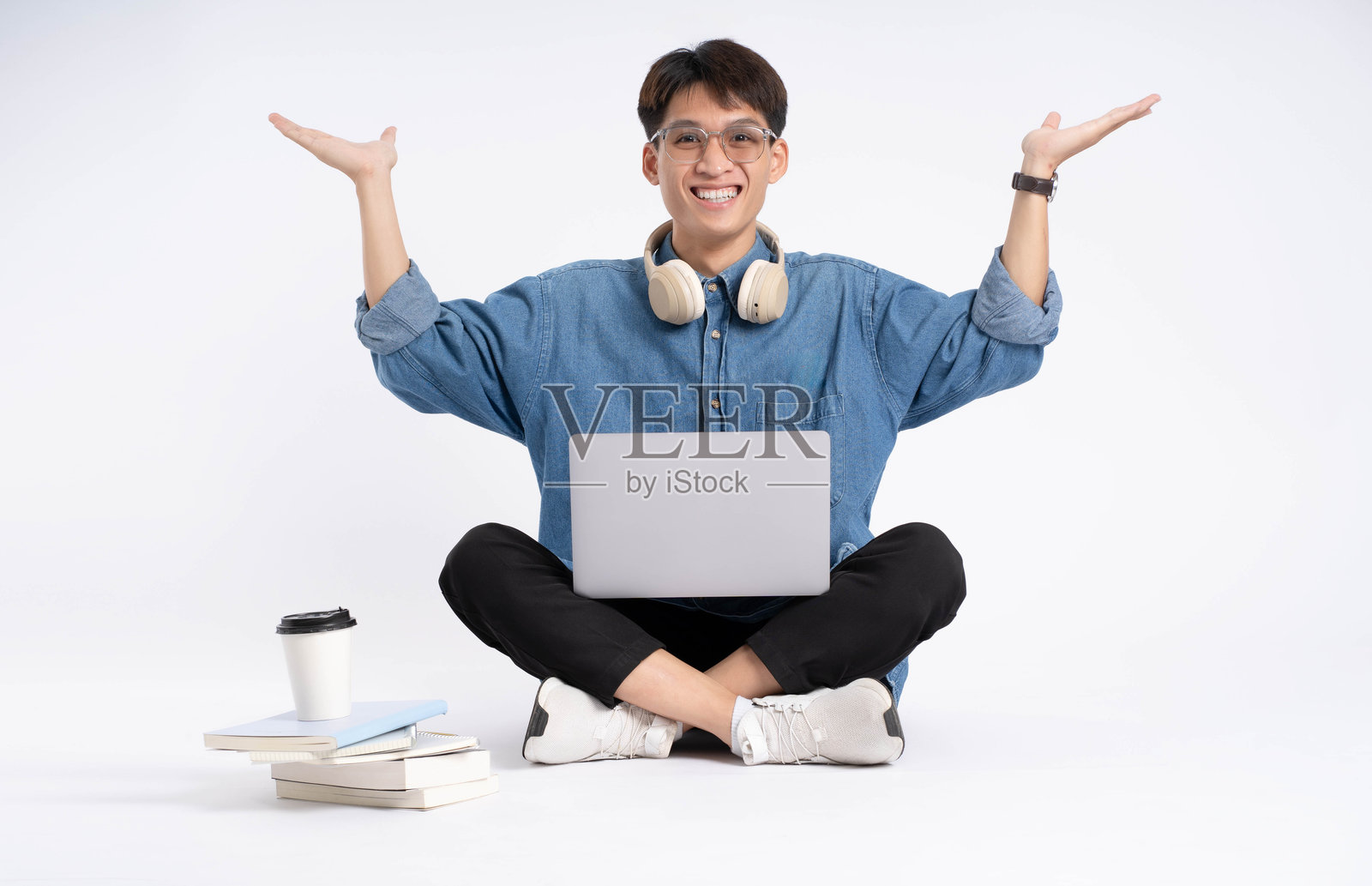 全身的亚洲男学生使用白色背景的笔记本电脑照片摄影图片