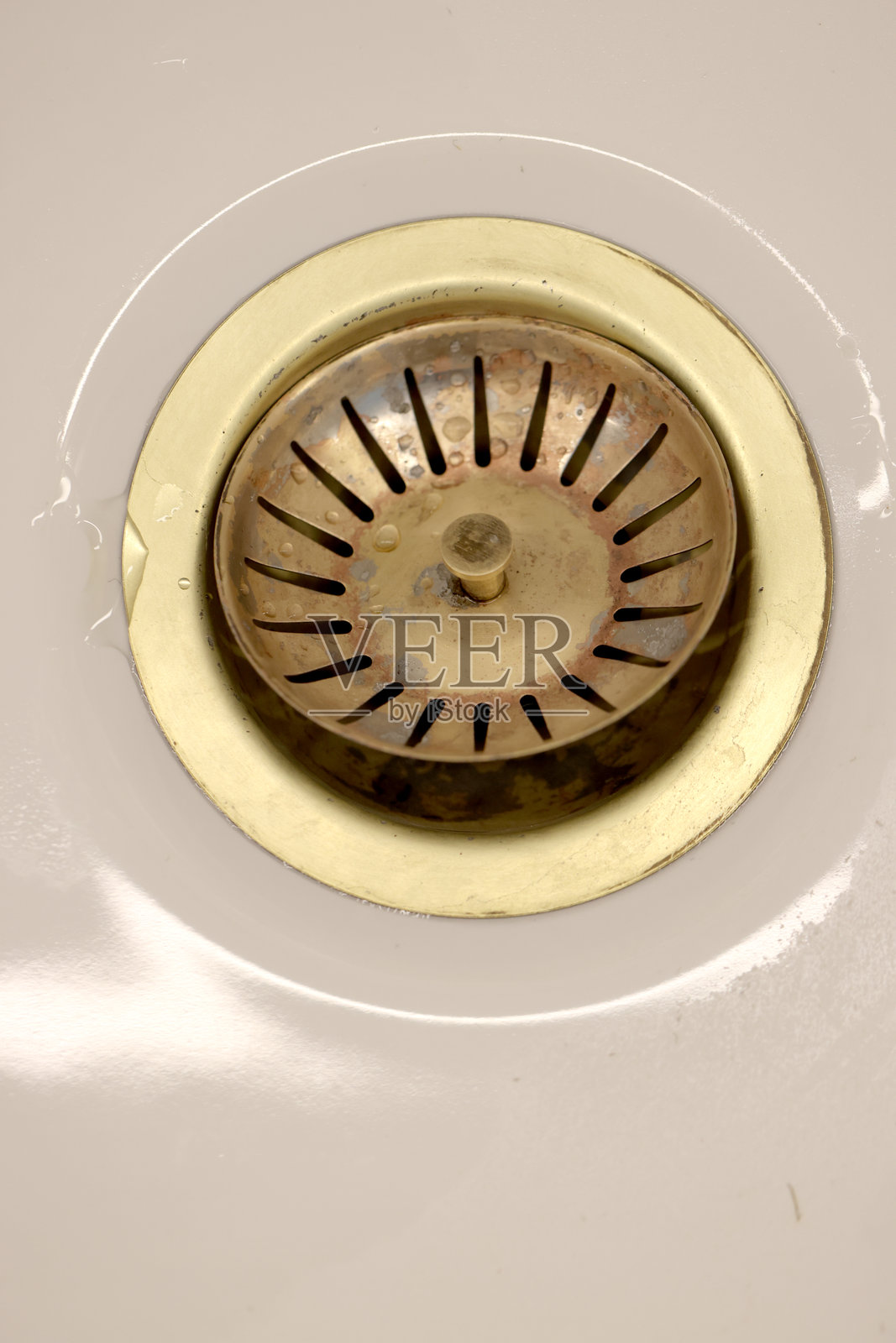 生锈的镀黄铜塞孔与内置的食品筛子在国内陶瓷水槽照片摄影图片