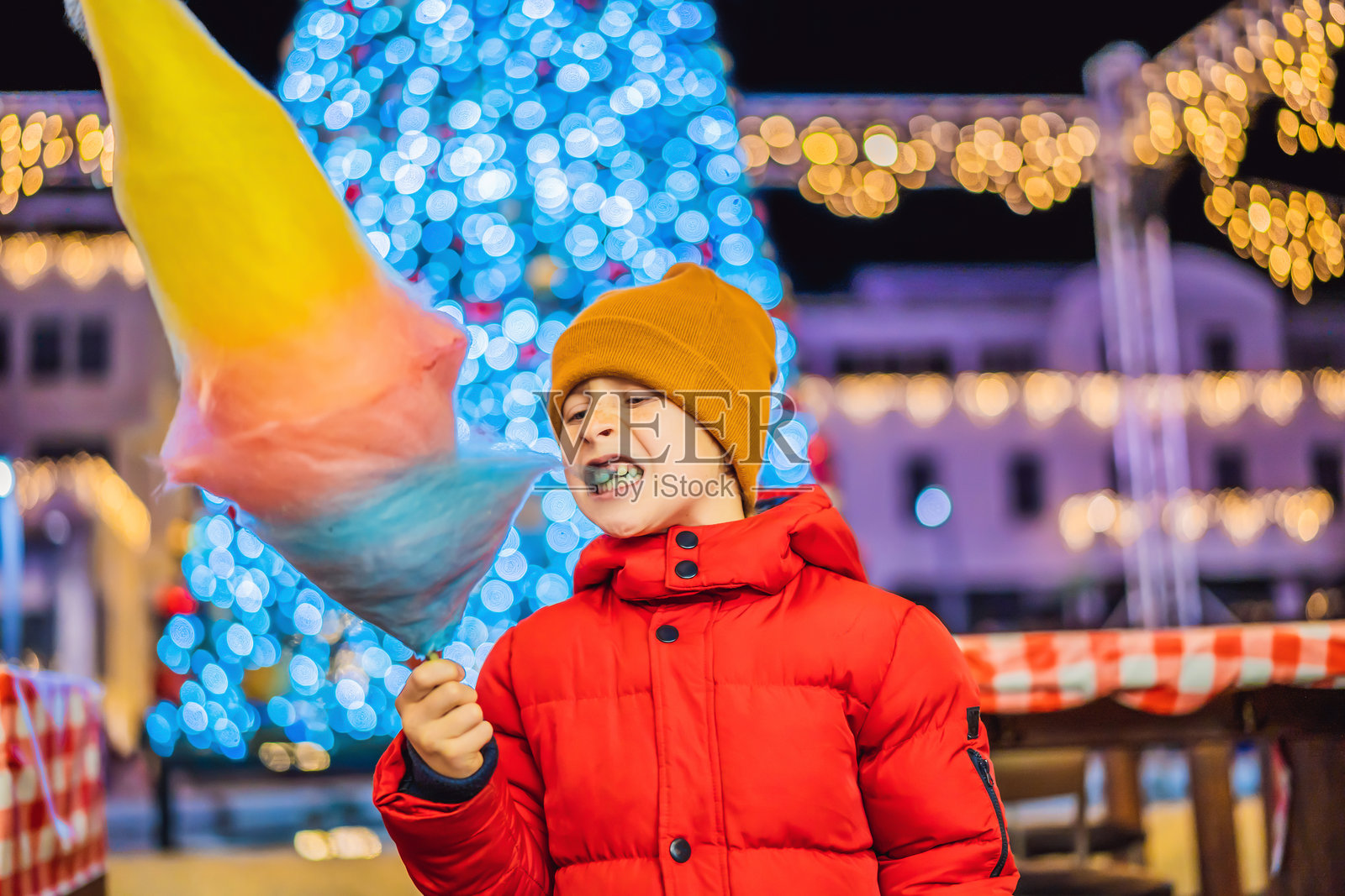 在圣诞市场拿棉花糖的男孩。圣诞市场上快乐的孩子。家庭在圣诞节的传统休闲照片摄影图片