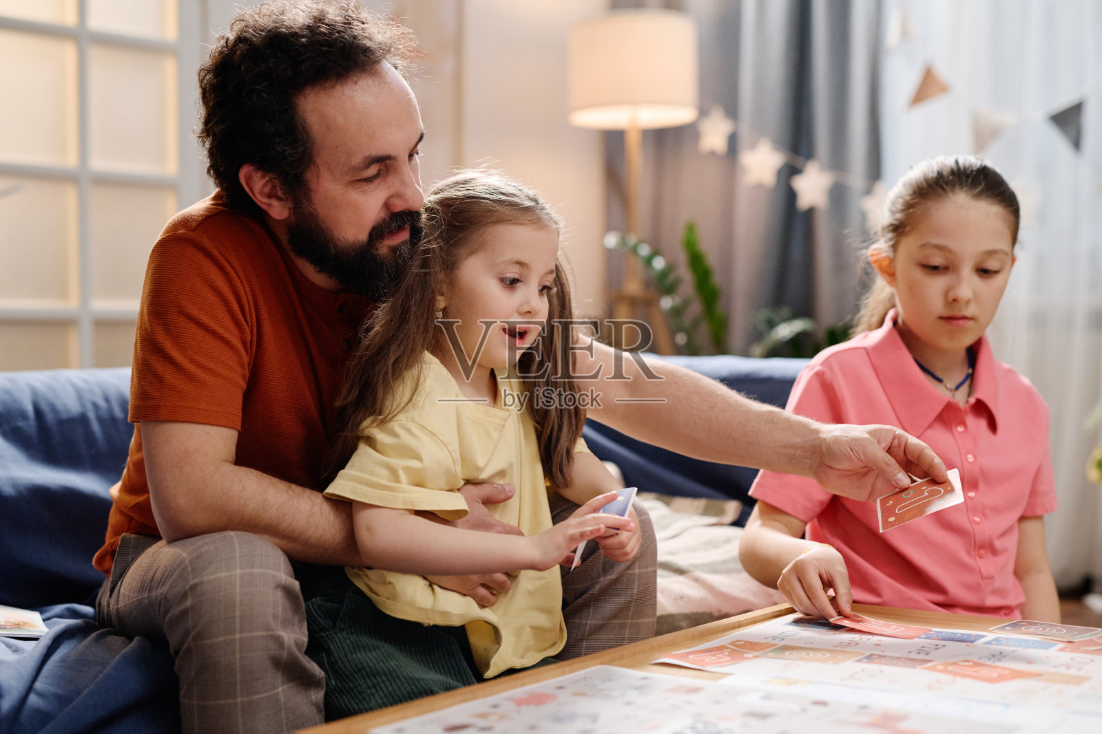 在舒适的客厅里一起玩棋盘游戏照片摄影图片