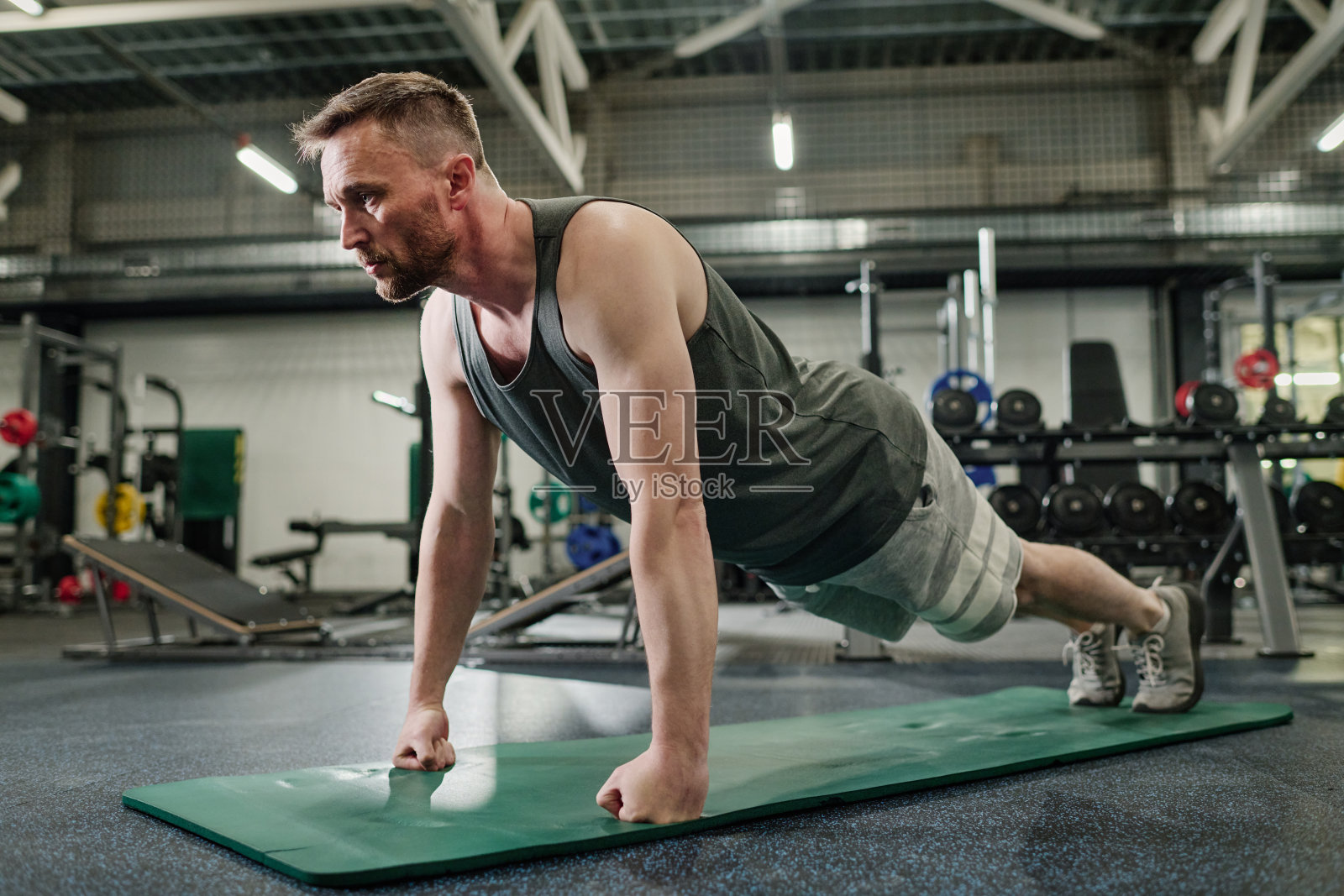 健美男子在垫子上做平板支撑照片摄影图片