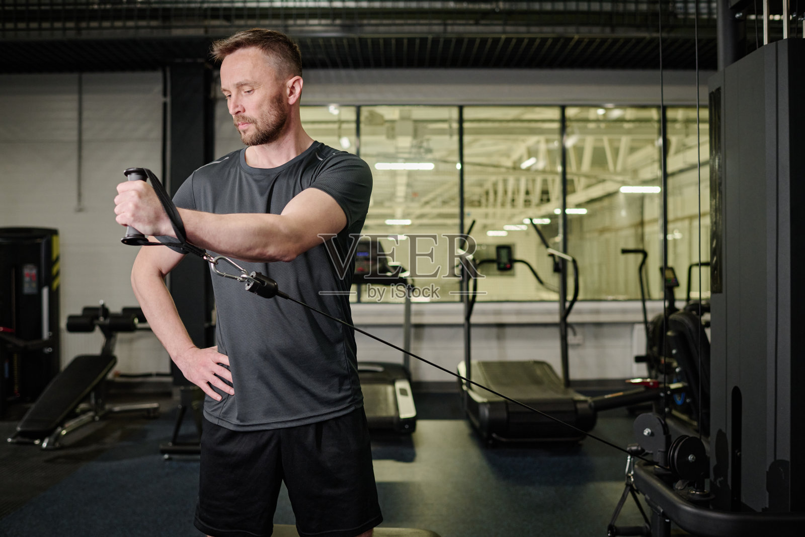 男子在现代健身俱乐部做运动照片摄影图片