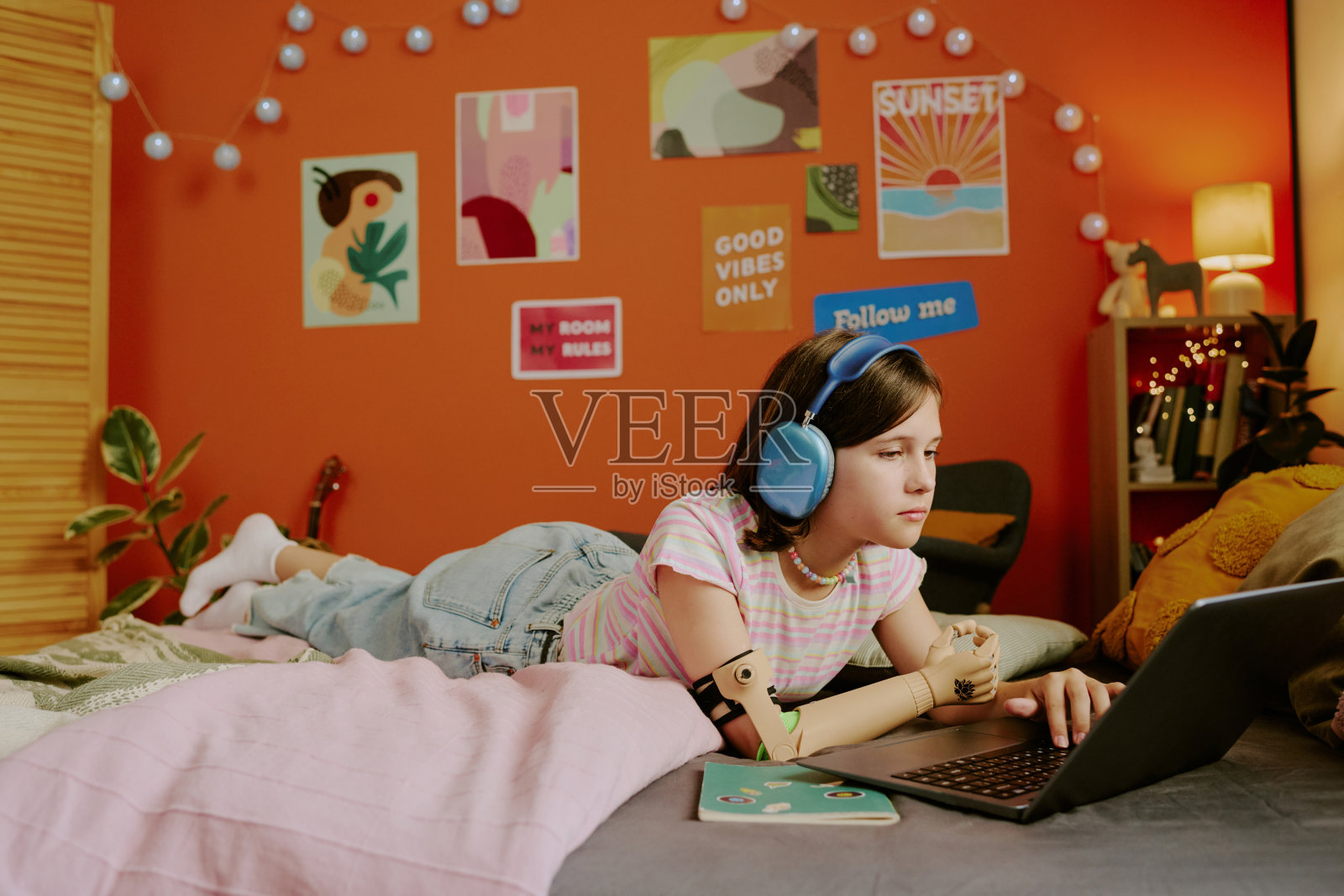 戴着耳机使用笔记本电脑的青少年照片摄影图片