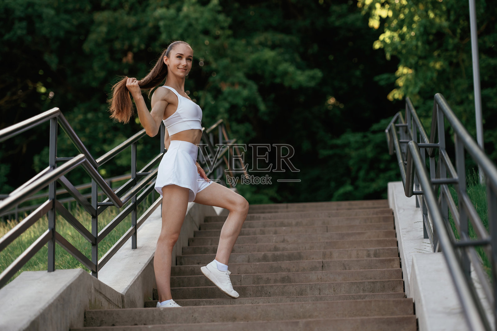 摆姿势,放松。年轻苗条的健身女子在户外照片摄影图片