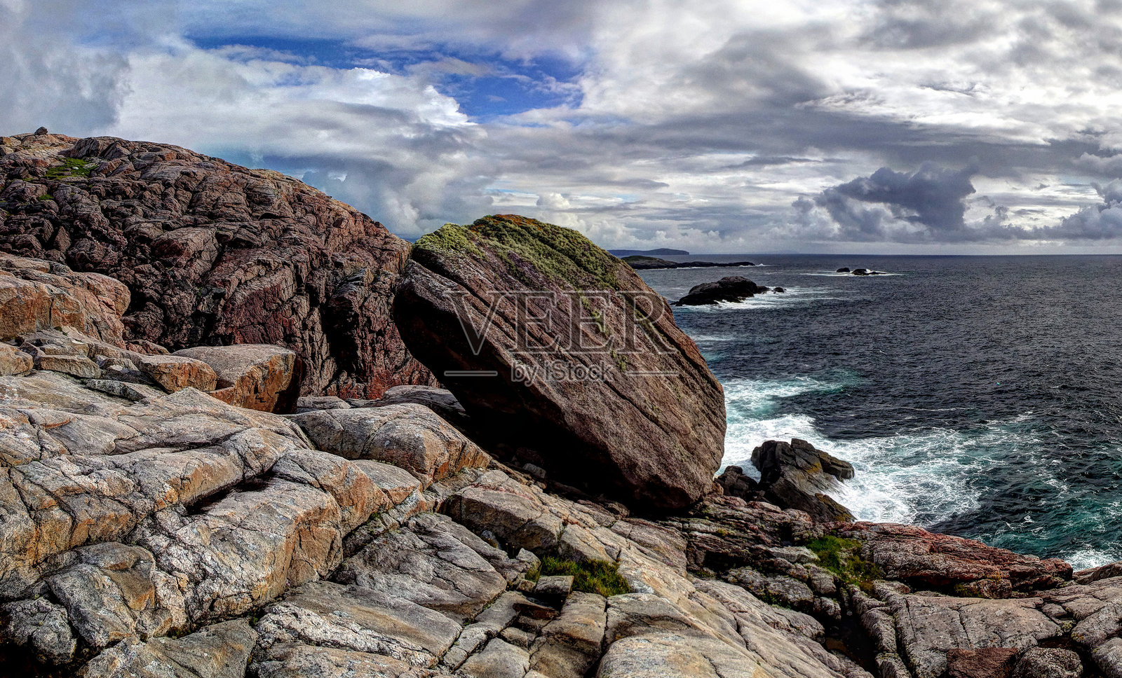 多云天空下的岩石海滩风景照片摄影图片