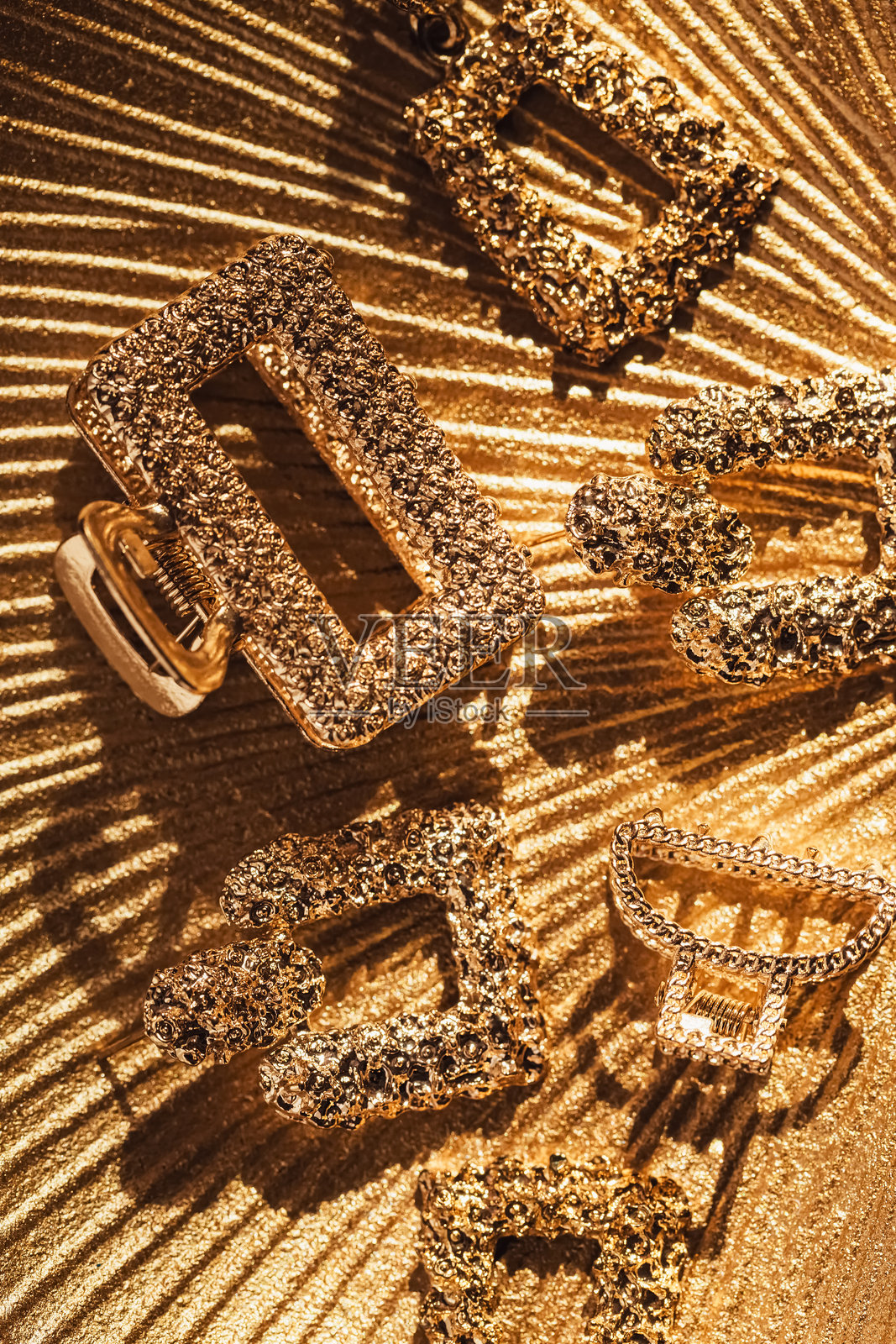 女性配饰的纹理背景与阴影。时髦的衣服配上金色的耳环和发夹。时尚美容理念照片摄影图片