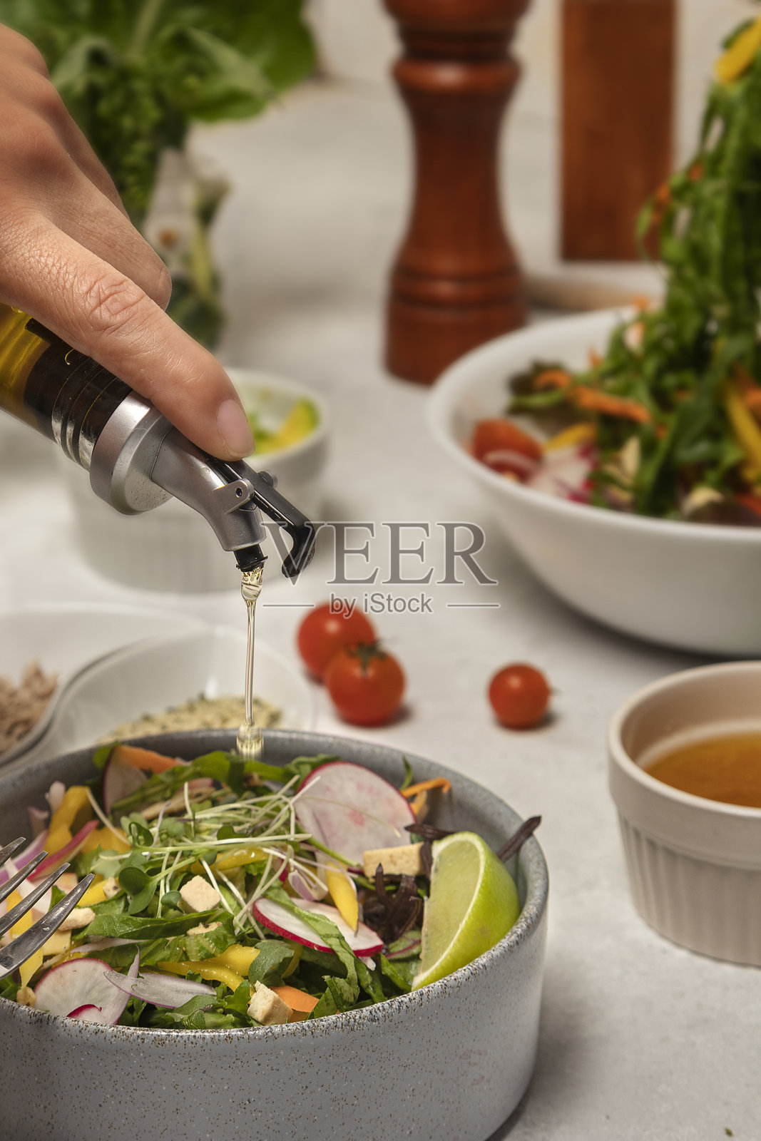 为素食者在混合萝卜沙拉中手工倒橄榄油照片摄影图片