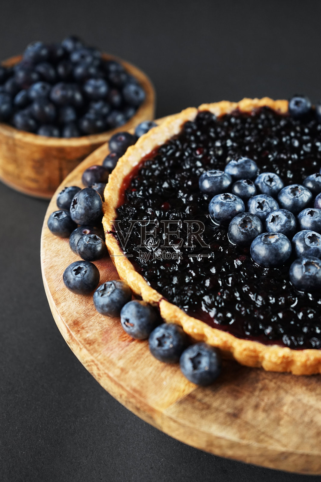 打开的蓝莓馅饼放在一个木架子上,旁边是新鲜的蓝莓照片摄影图片