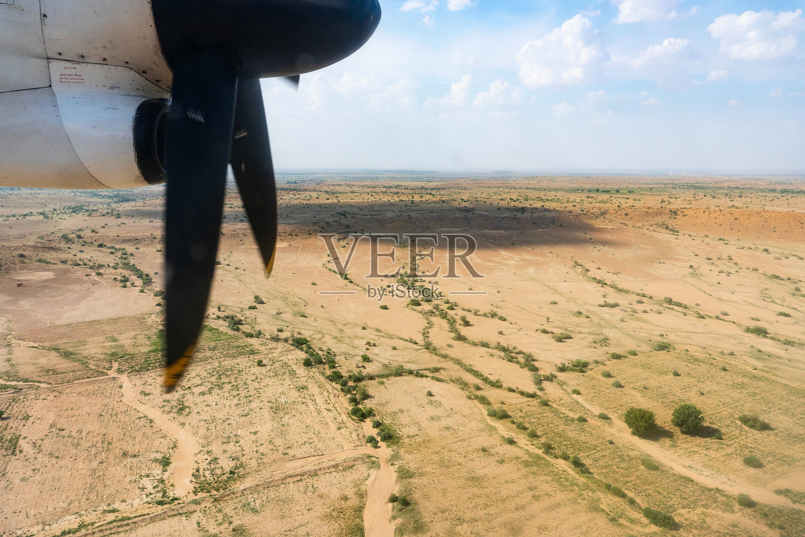 印度拉贾斯坦邦,从飞机上俯瞰塔尔沙漠的美景。螺旋桨和框架里的沙漠。阳光和云层的影子在沙漠下面的游戏。照片摄影图片