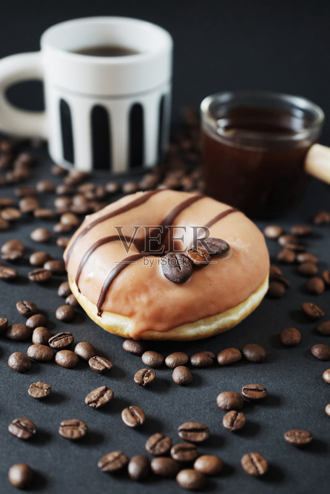 焦糖甜甜圈与咖啡装饰旁边的杯子黑咖啡和玻璃杯勺咖啡照片摄影图片