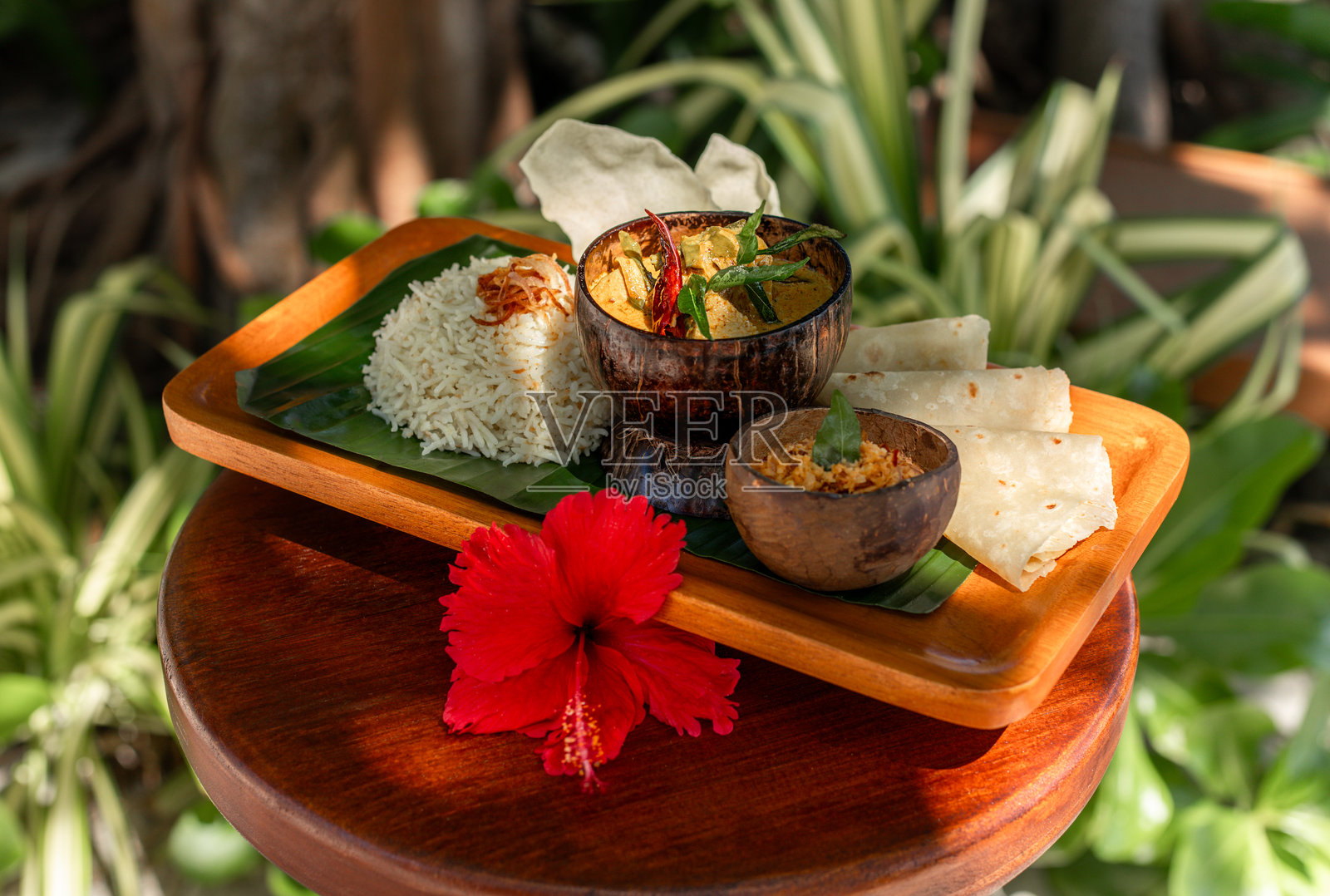 马尔代夫椰子咖喱菜,配金枪鱼、茉莉花米饭和桑巴酸辣酱,配椰子壳和香蕉叶照片摄影图片