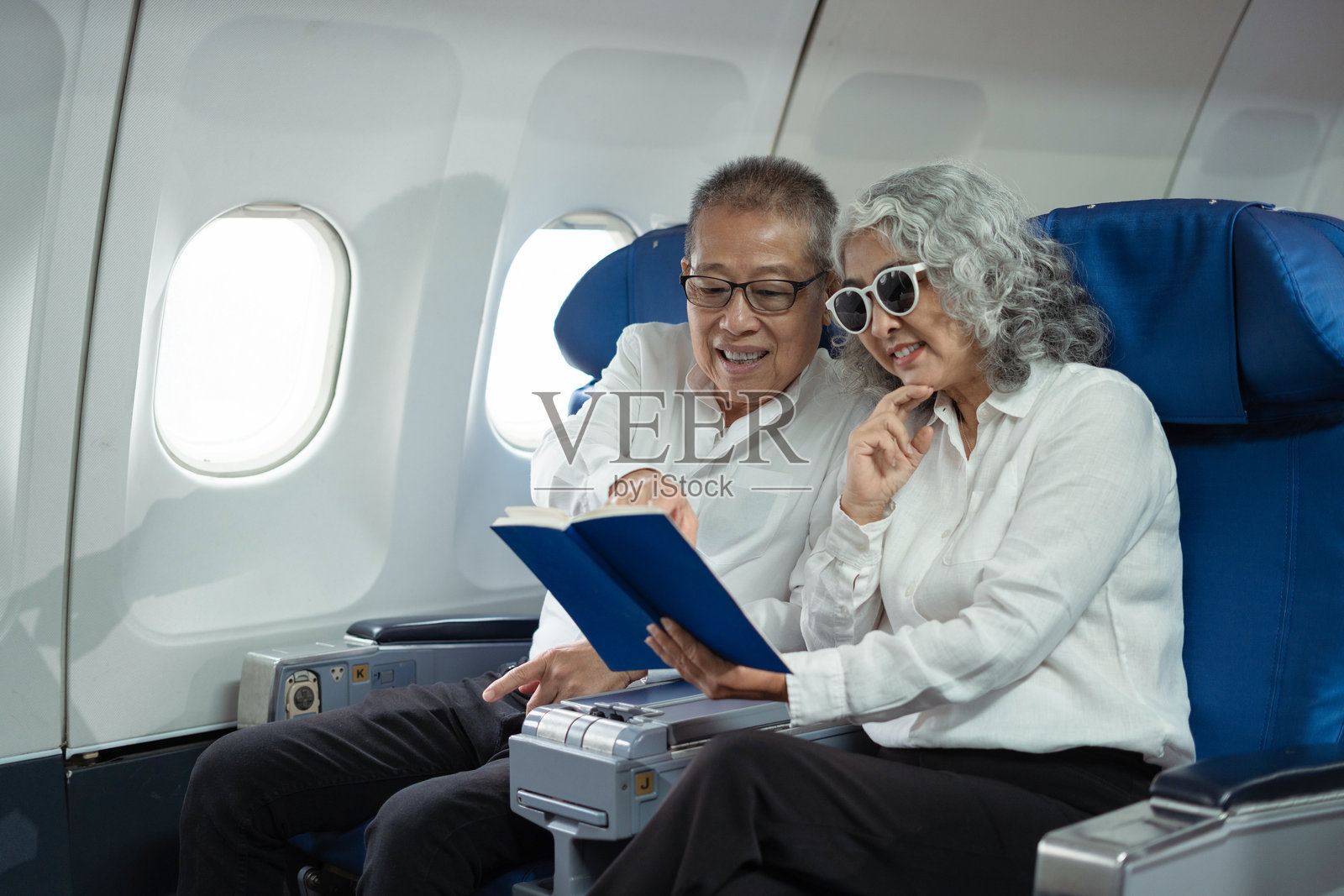 一对成熟的夫妇坐在私人飞机上,准备去旅行照片摄影图片