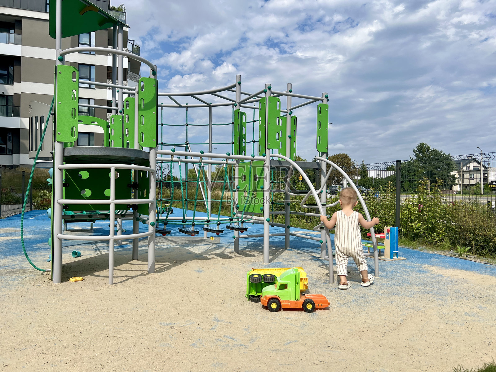 一个小孩正在操场上玩玩具滑梯照片摄影图片