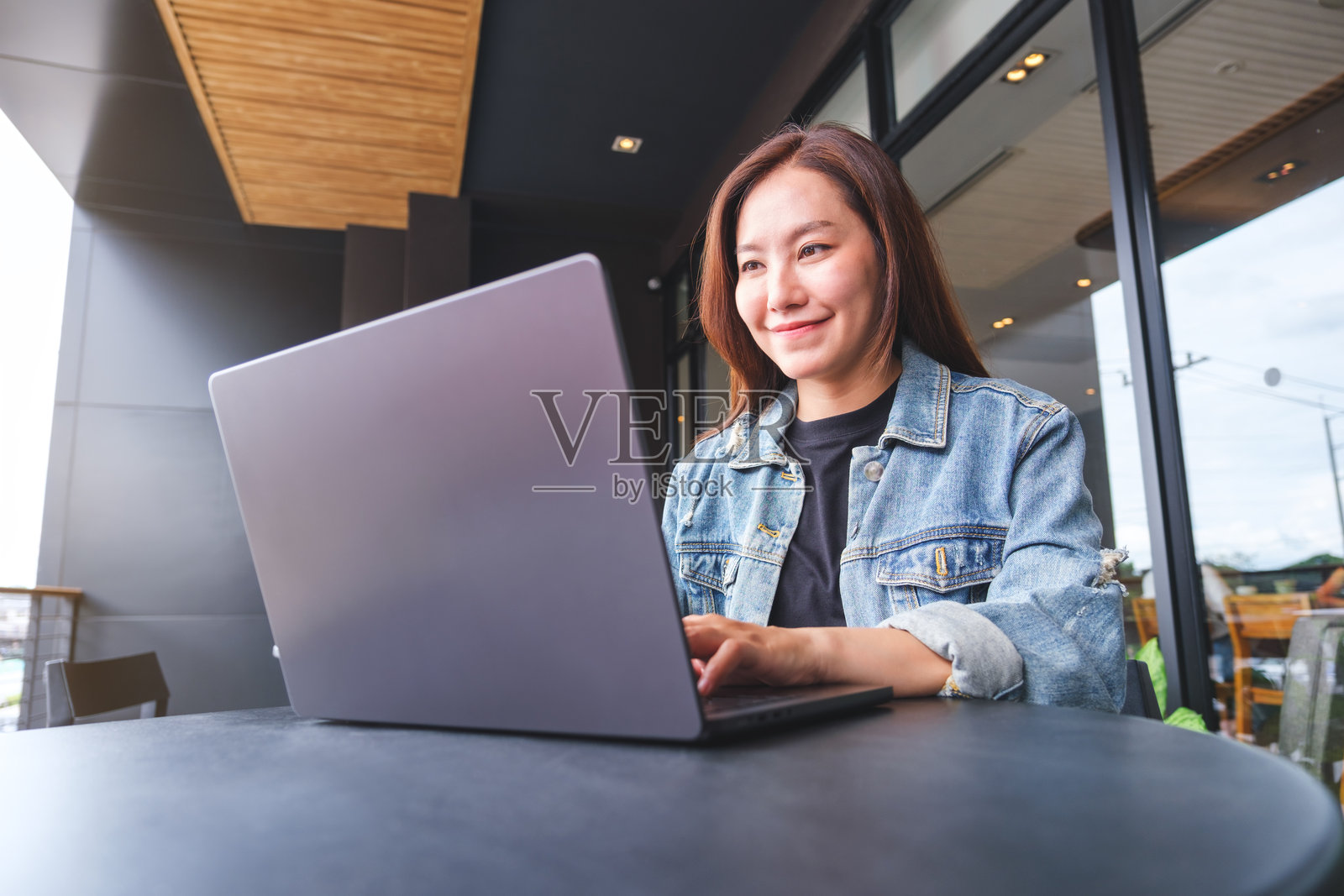 一个年轻女子在咖啡馆用笔记本电脑工作的肖像照片摄影图片