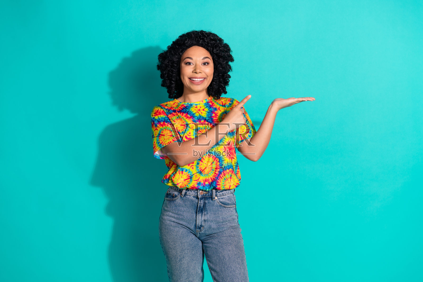 照片正面迷人的女人穿着时尚的衣服展示了青色背景上孤立的空白空间照片摄影图片