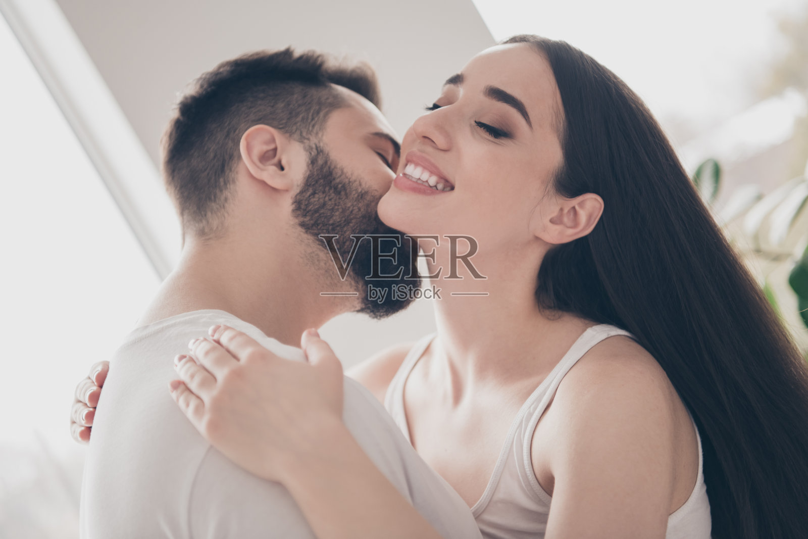 幸福的年轻夫妇的照片,搬家新地方享受住在一起,丈夫亲吻脖子,妻子有乐趣,新的公寓房间,灯光,房子,公寓,室内照片摄影图片