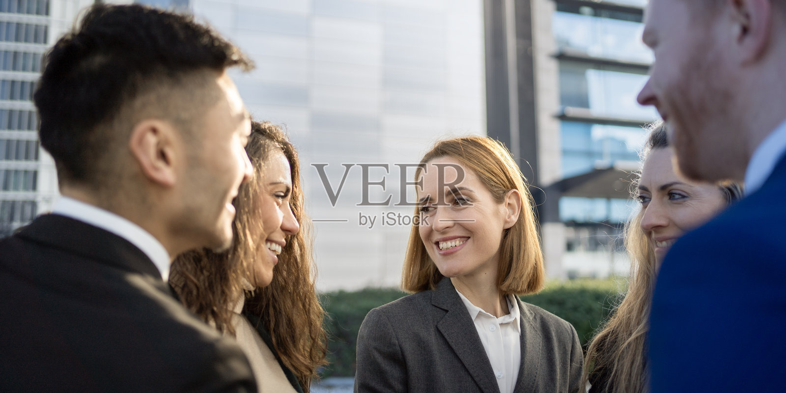 一群商人站在外面,因为团队的成功而高兴照片摄影图片