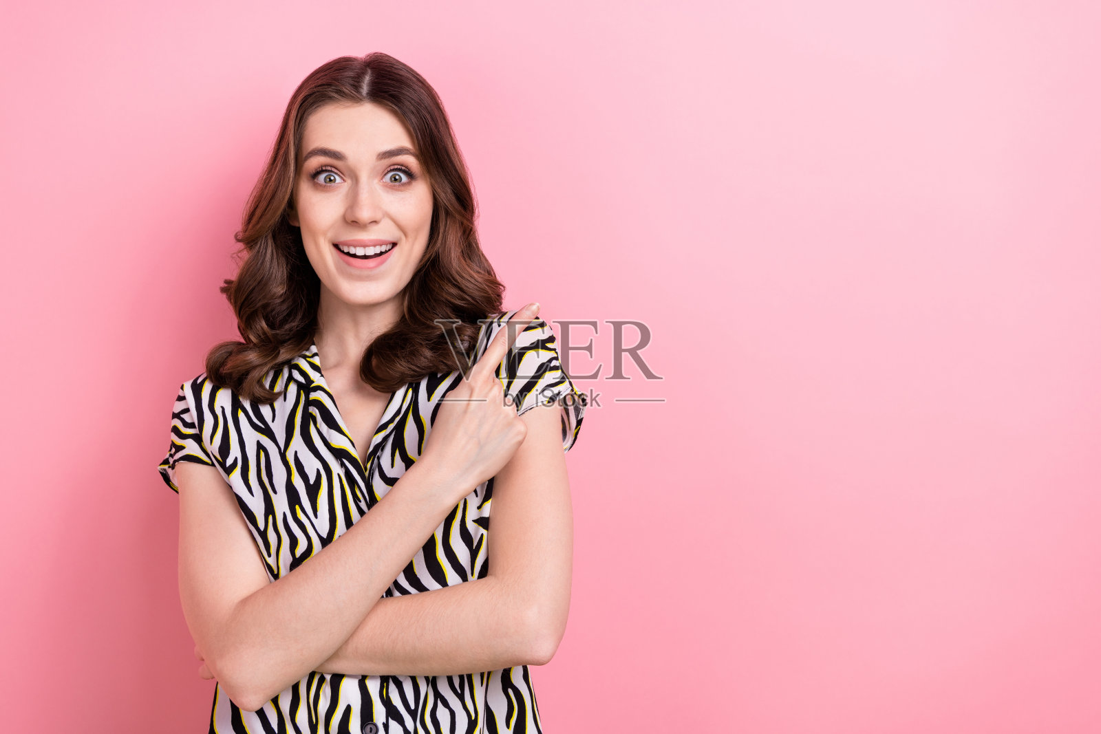 惊讶的魅力模特女孩直接手指空白的照片令人难以置信的反应好消息广告孤立在粉红色的背景照片摄影图片