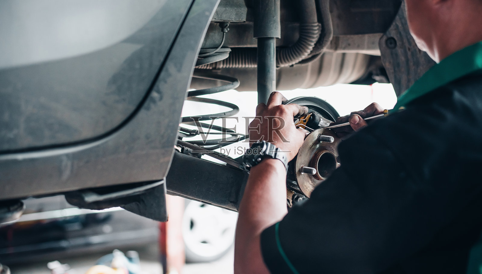 修车师在车库里修理汽车刹车照片摄影图片