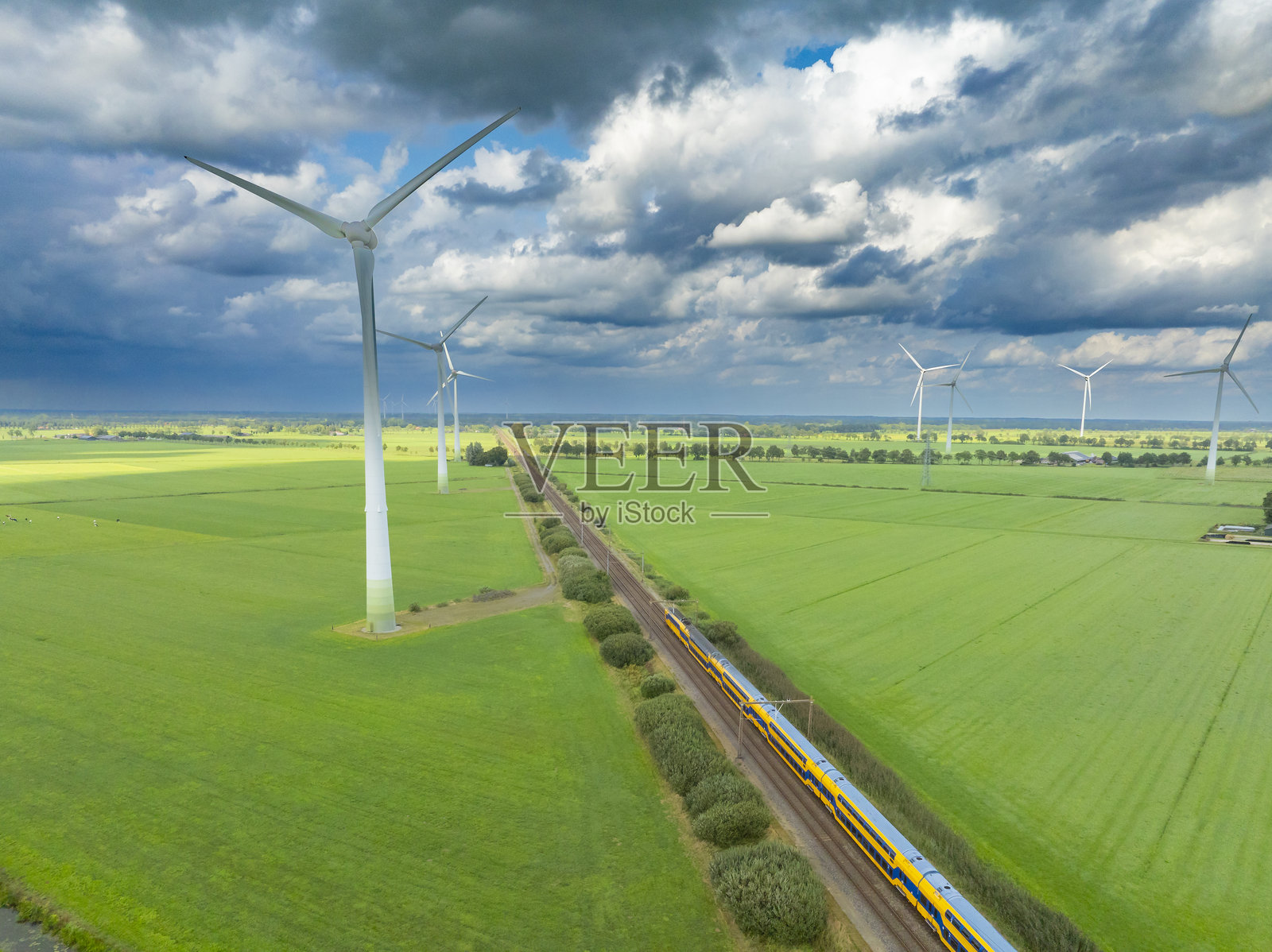 荷兰铁路的火车驶过风力涡轮机照片摄影图片