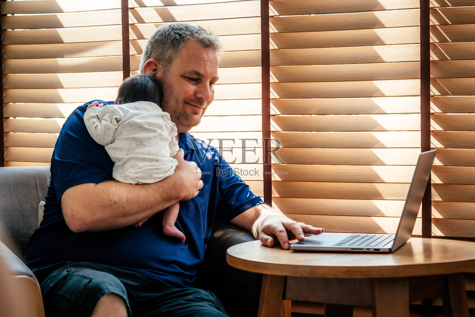 父亲带着刚出生的女婴使用笔记本电脑照片摄影图片