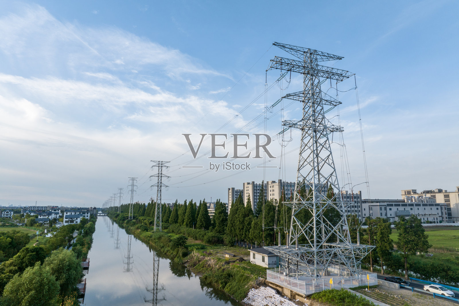 蓝天下农田上高压电线铁塔照片摄影图片