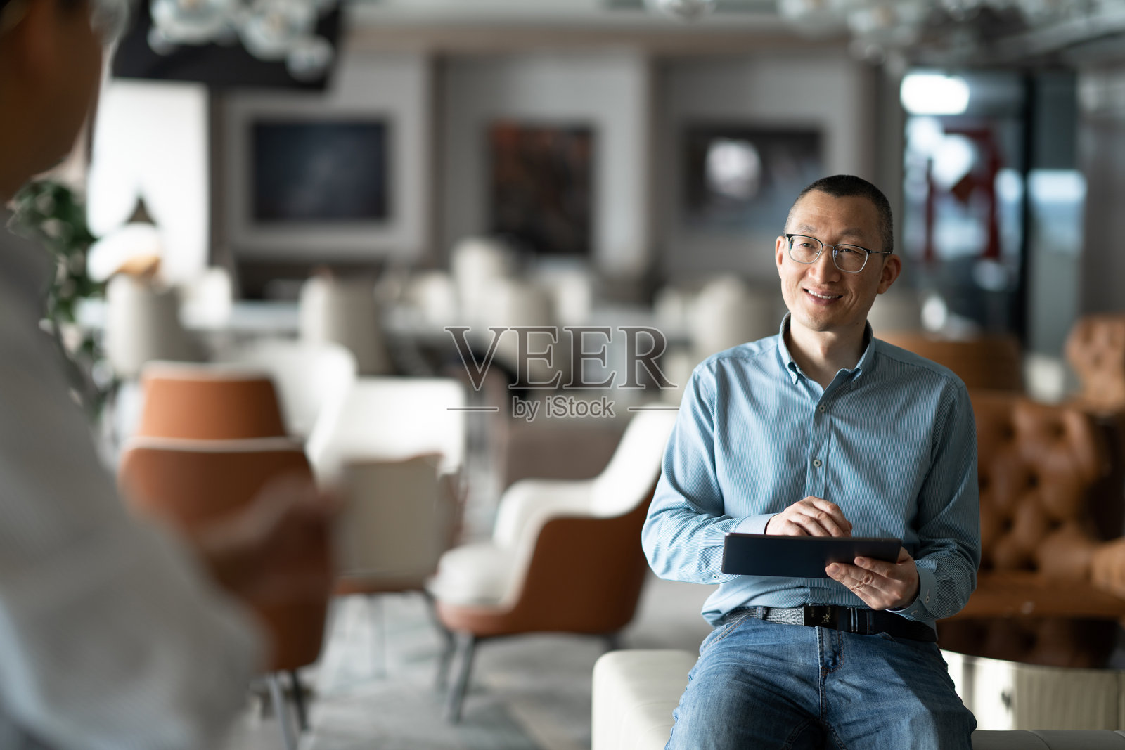 商务人士在办公场所使用平板电脑洽谈业务照片摄影图片