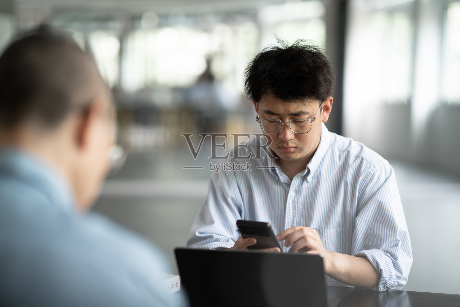 商务人士室内使用手机照片摄影图片