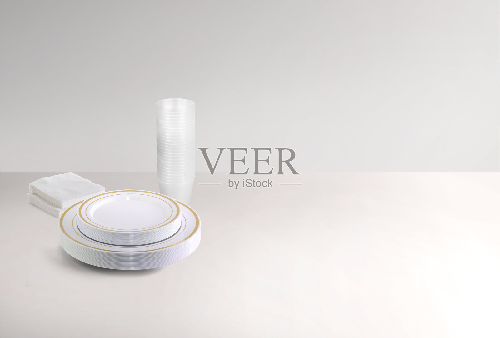 一叠干净的盘子、餐巾和杯子照片摄影图片