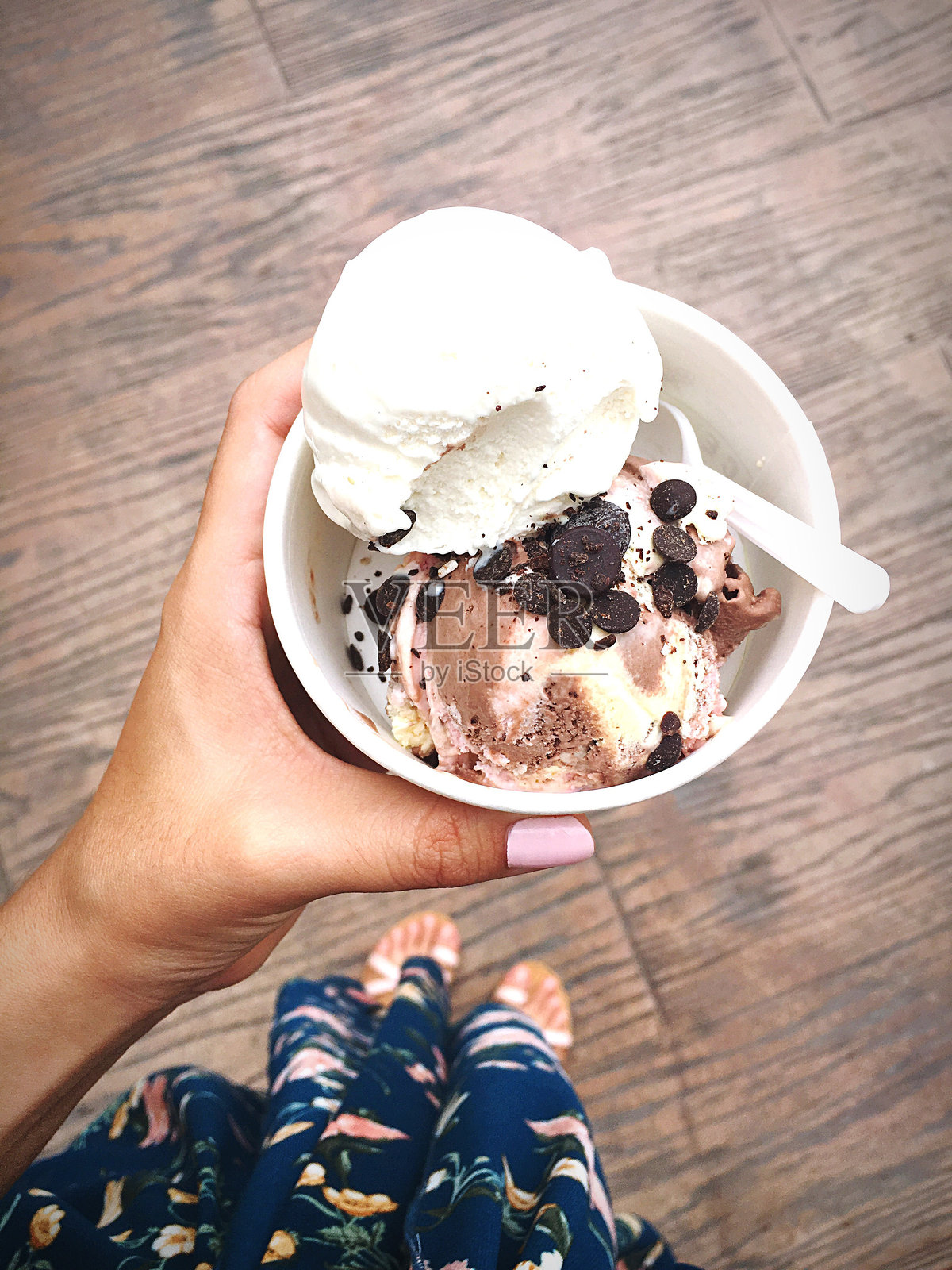 人行道上拿着冰淇淋的女人的下半身照片摄影图片